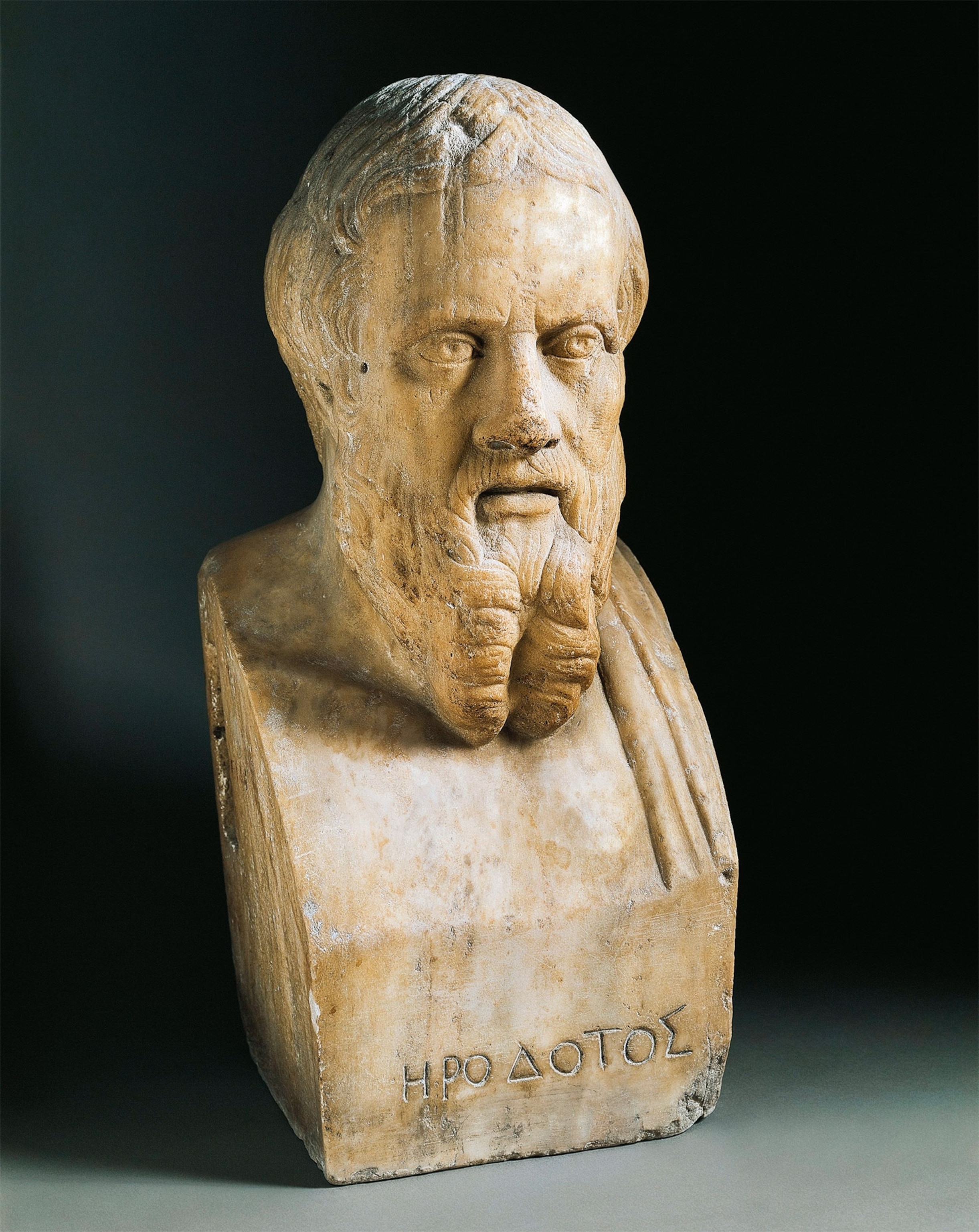 A stone bust of a man with a beard