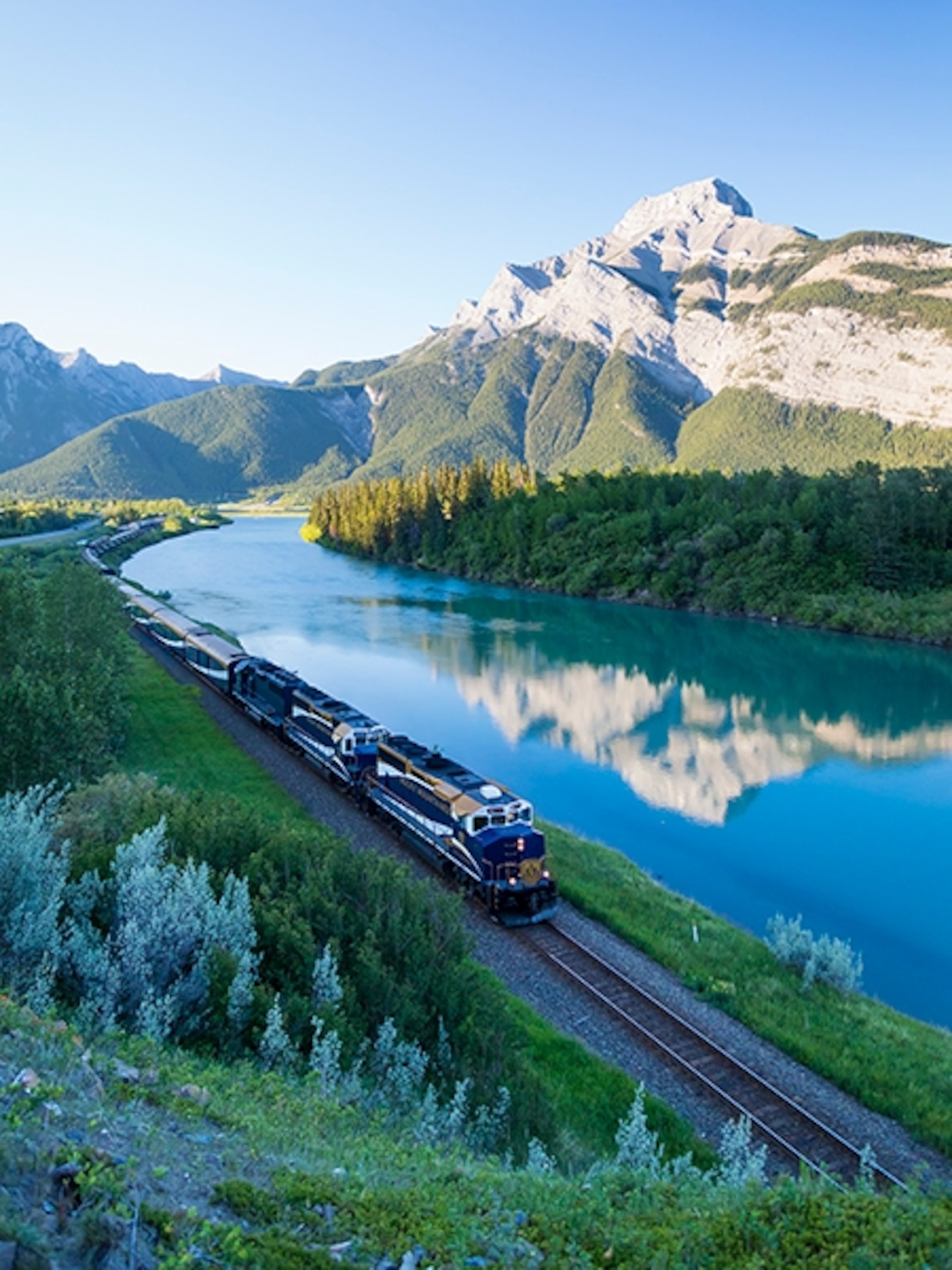 the Rocky Mountaineer passenger train as seen at dawn near Exshaw, Alberta, Canada