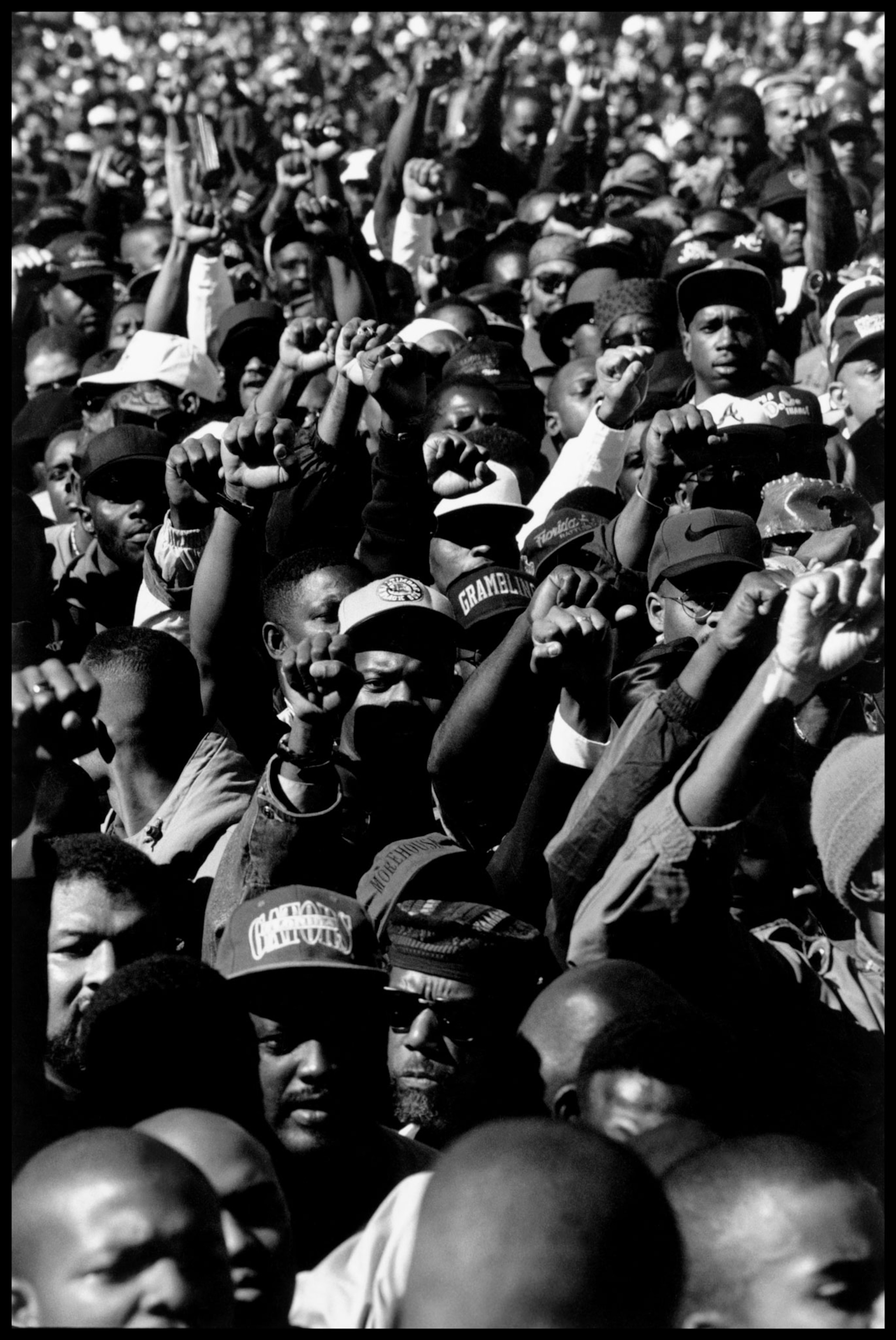 a thick crowd of Black men raising their fist