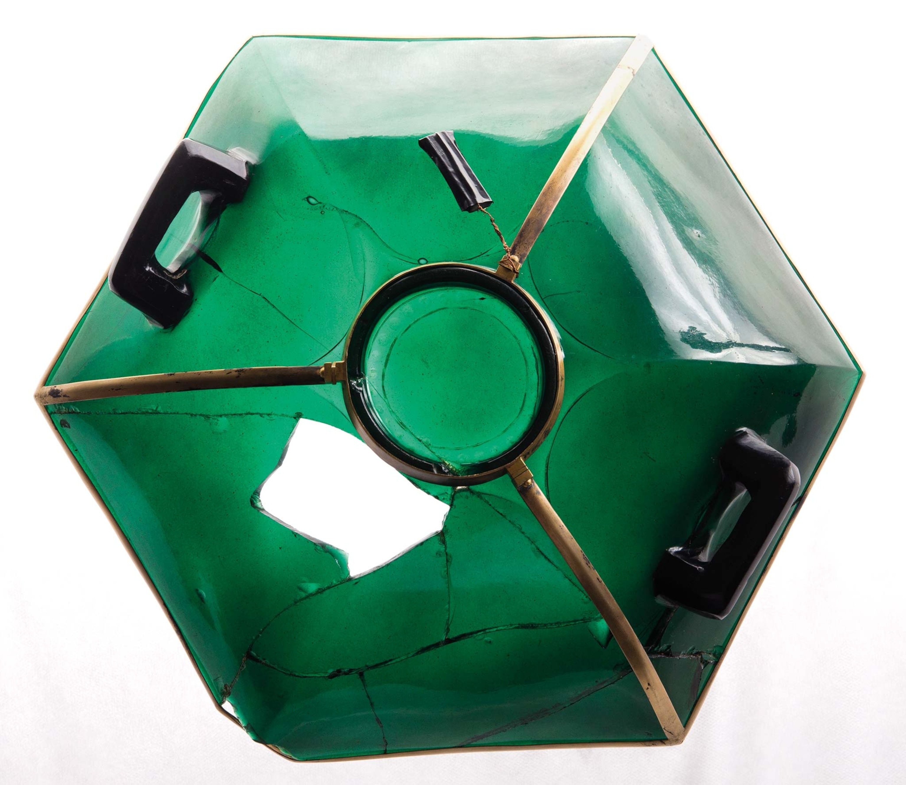 An overhead view of a carved emerald-colored vessel with a hole in it