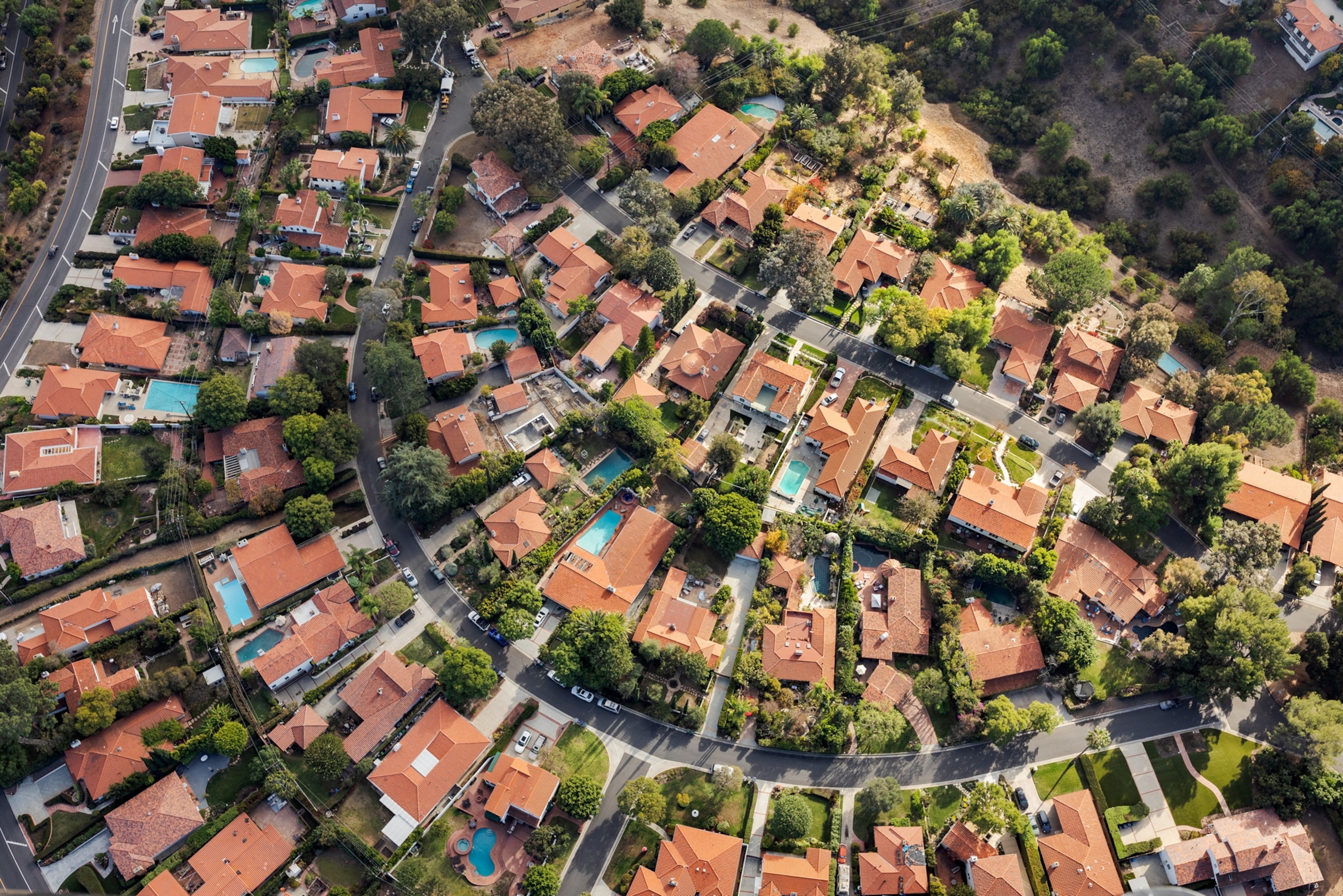 Picture of aerial view of green neighborhood with privet swimming pools.