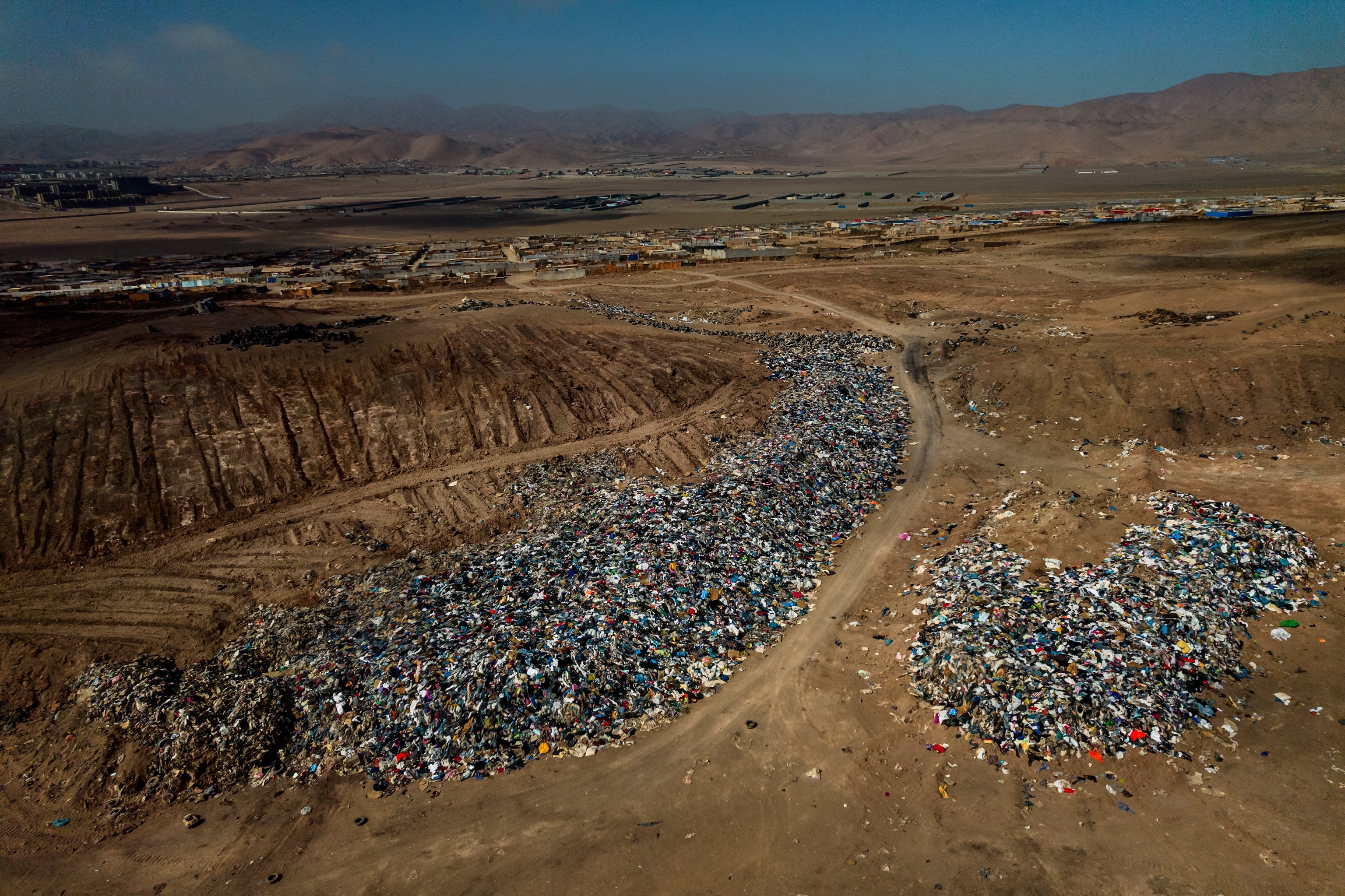 overview shot of how large the dumping group for clothes is compared to the village in the back.