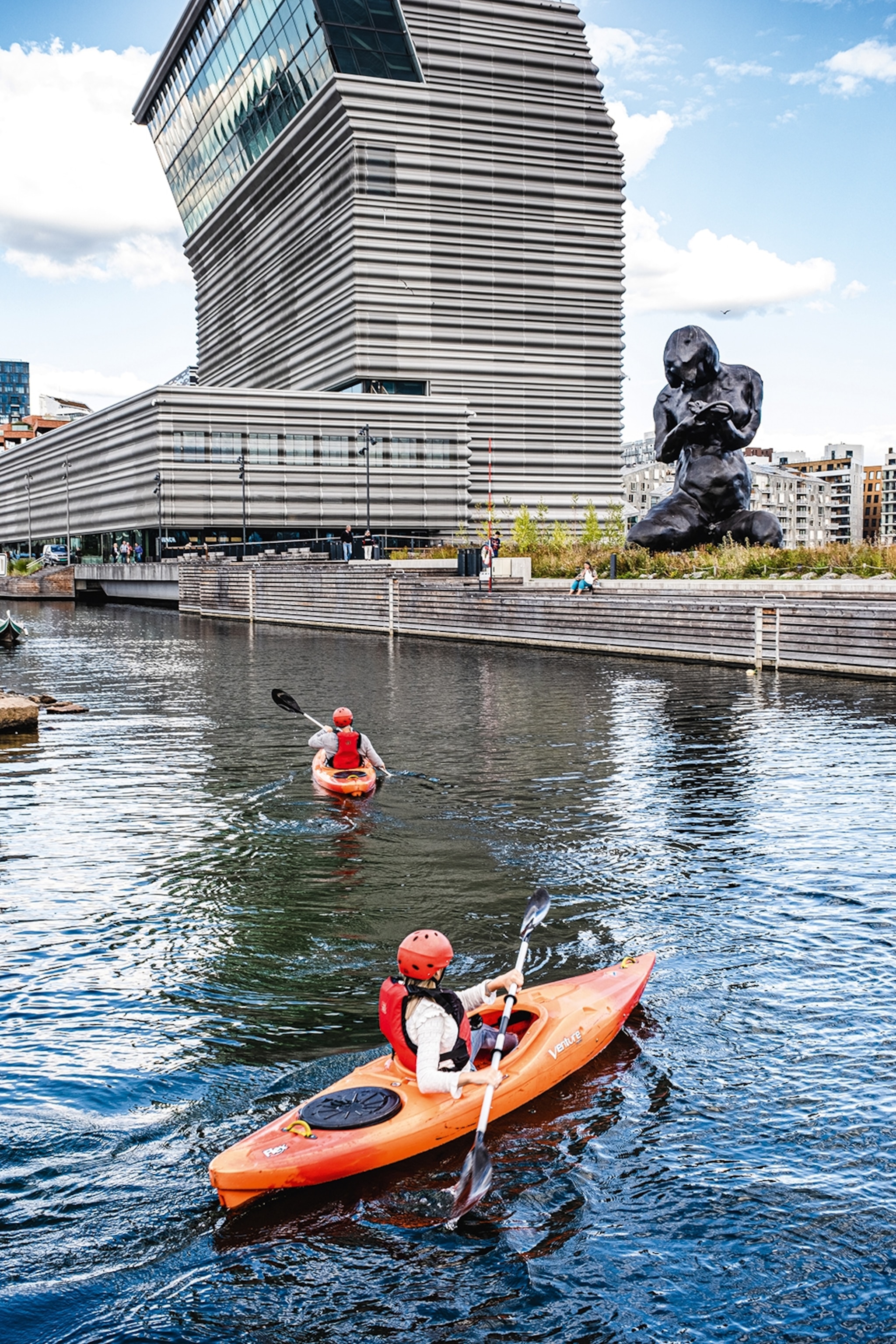 Two people kayaking against the backdrop of the Munch Museum, and The Mother, a Tracey Emin sculpture.