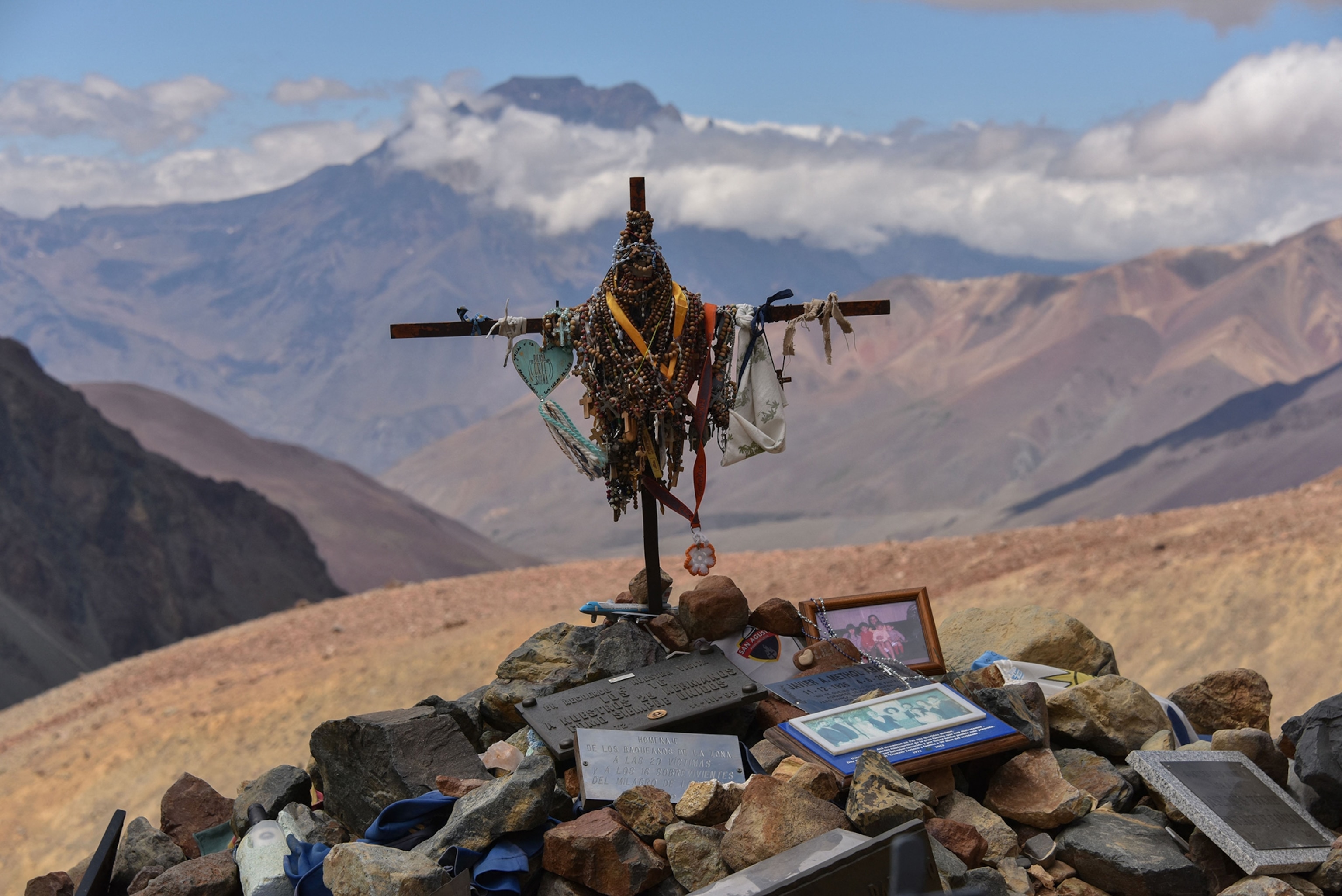 Picture of the cross on the grave of the victims of the Andes flight disaster of 1972 with mountains in the background.