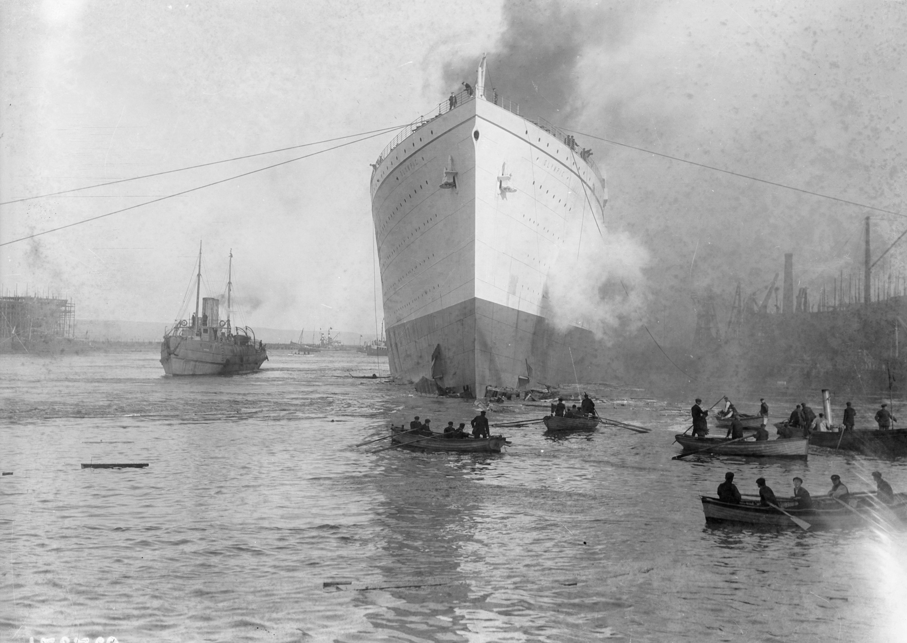 Photo of ship in harbor with row boats in foreground