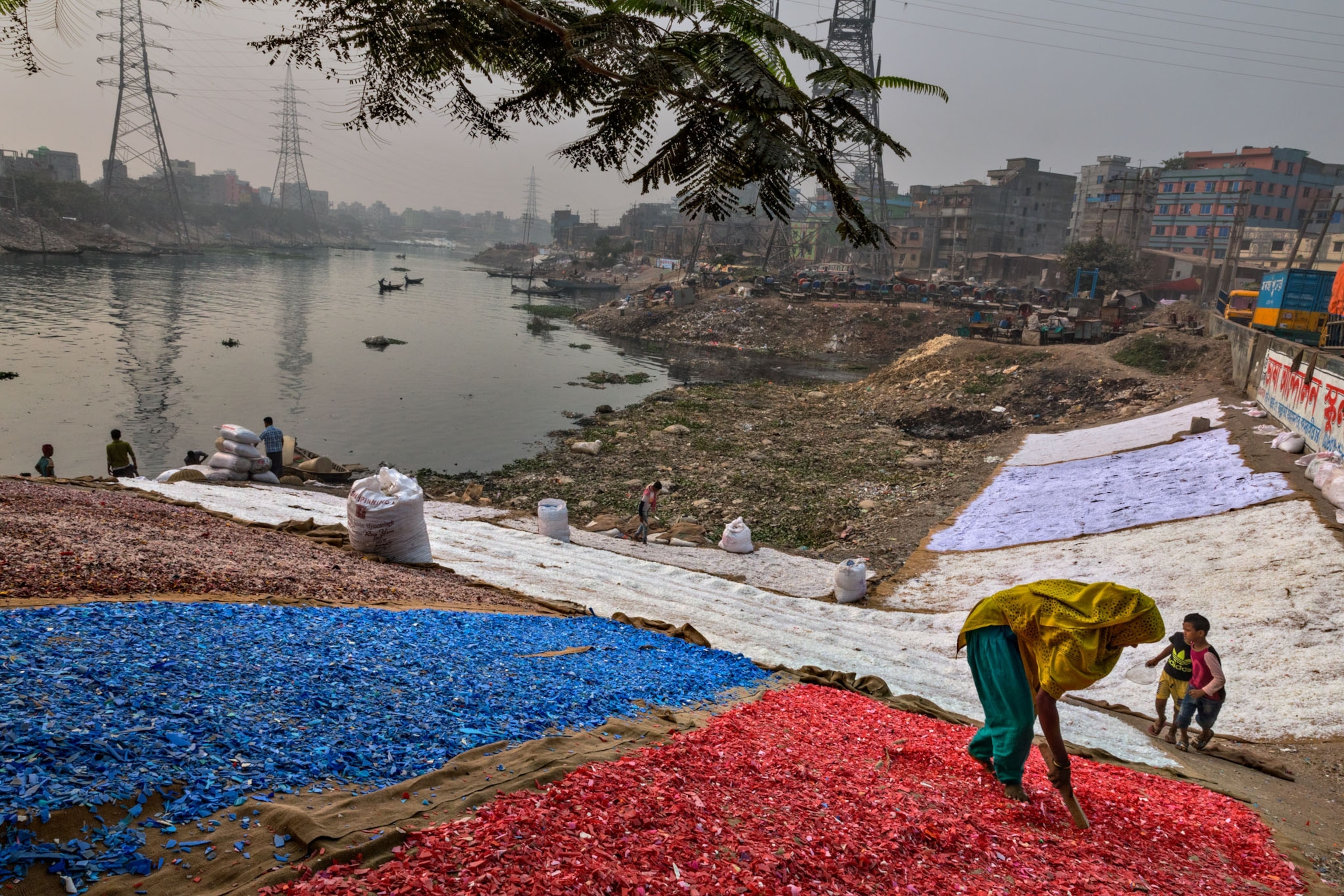 colored chips of plastic sorted by people on the banks of a river