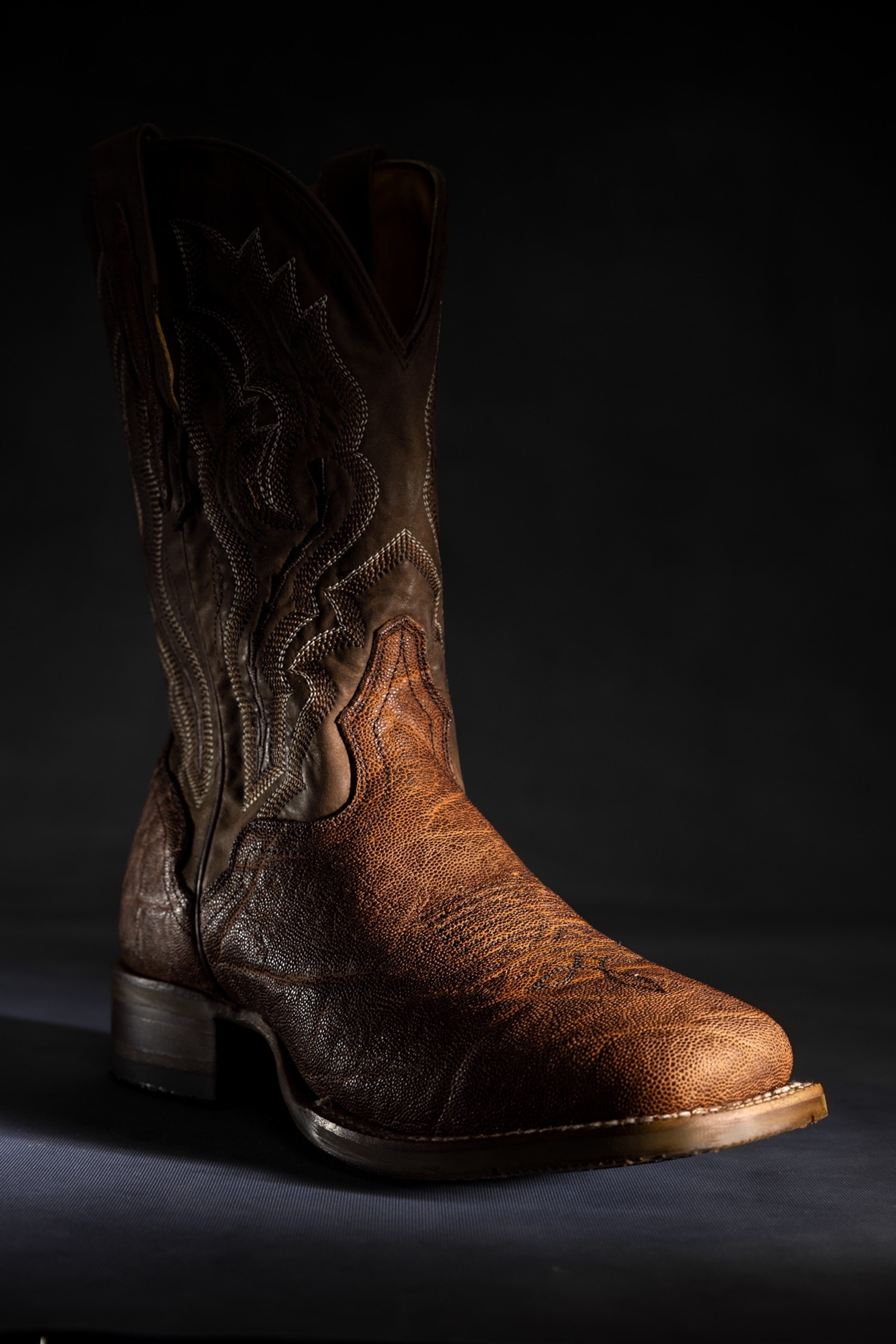 Picture of brown leather cowboy boot with intricate stitch work.