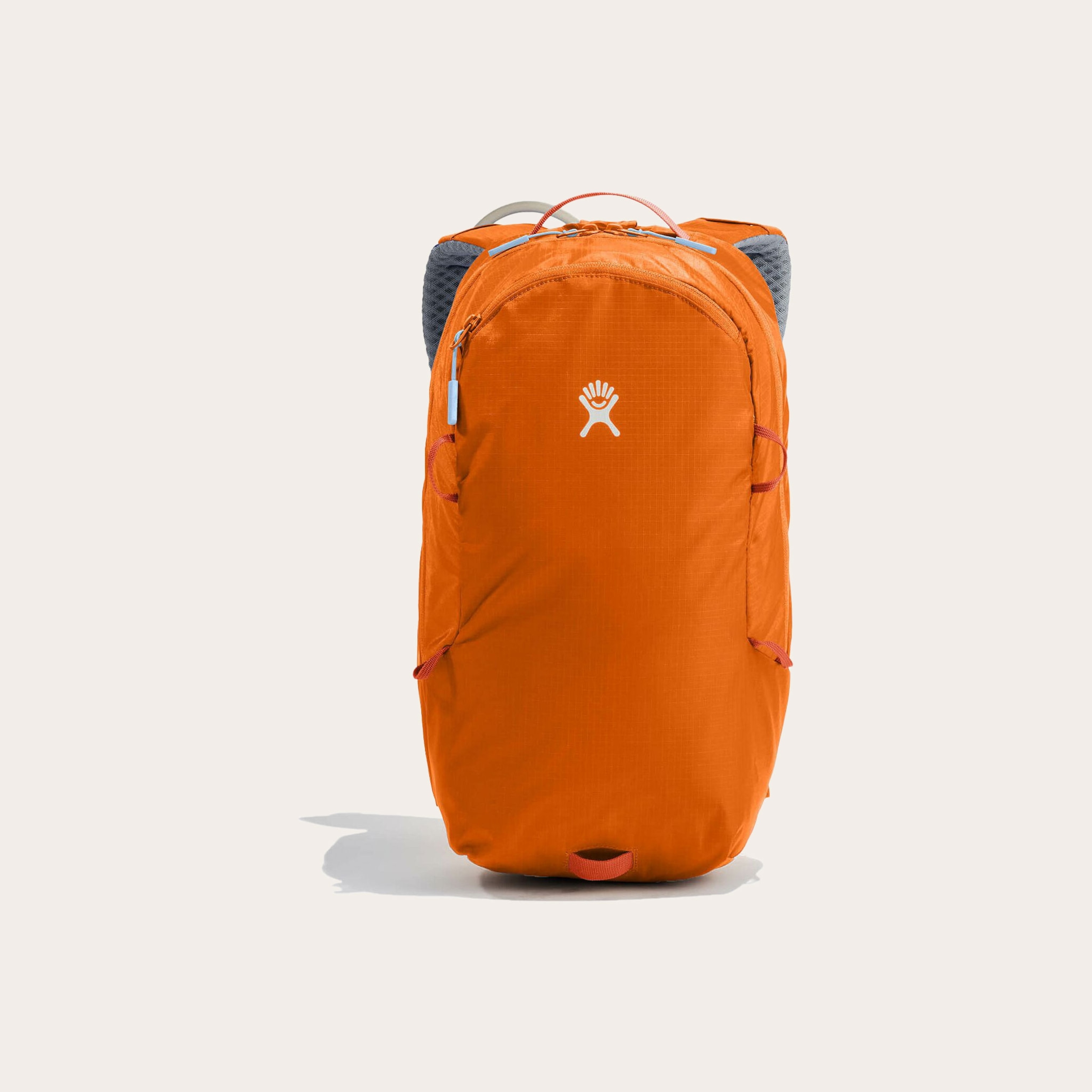 Orange backpack sitting on tan background.