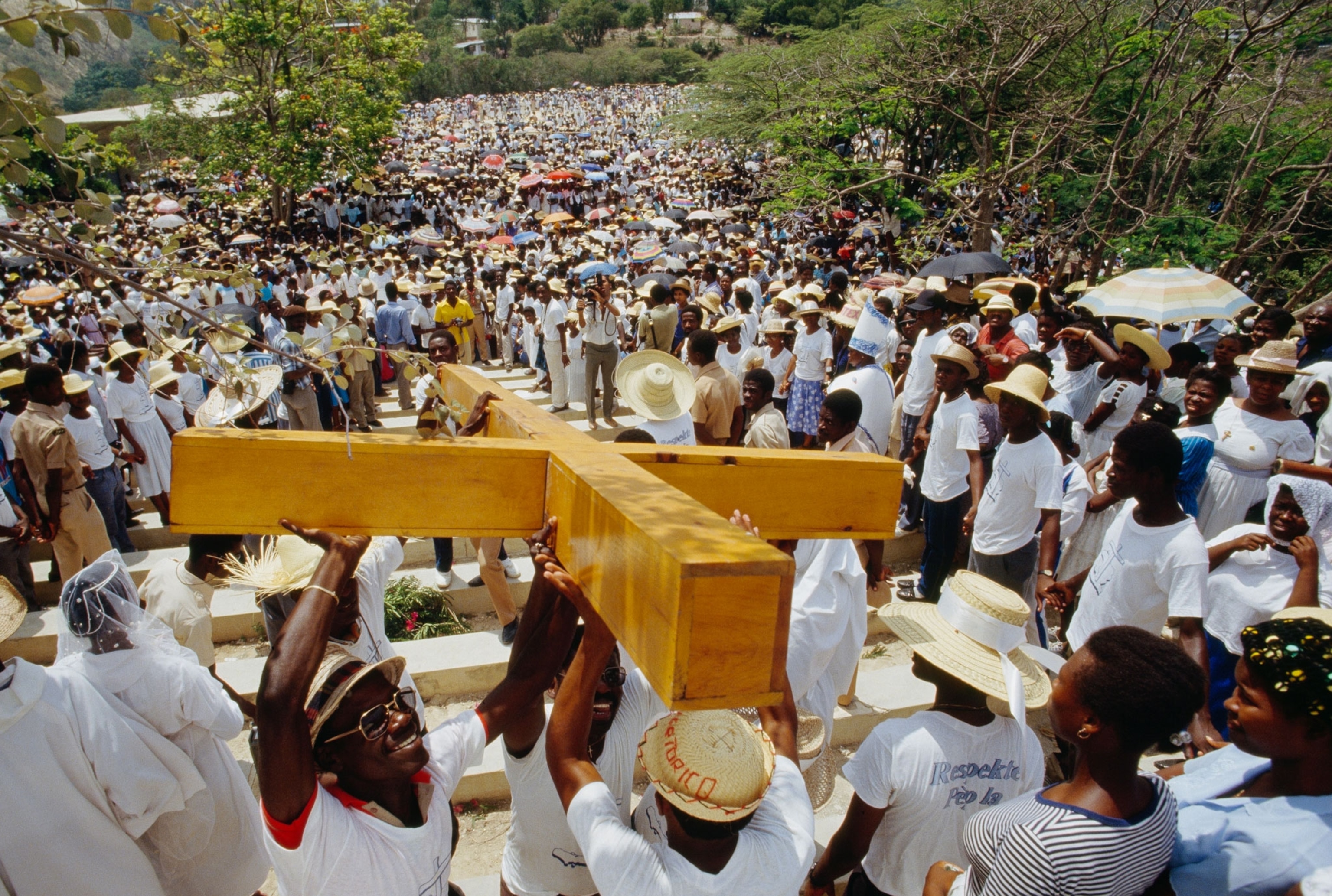 a crowd carrying a large wooden cross