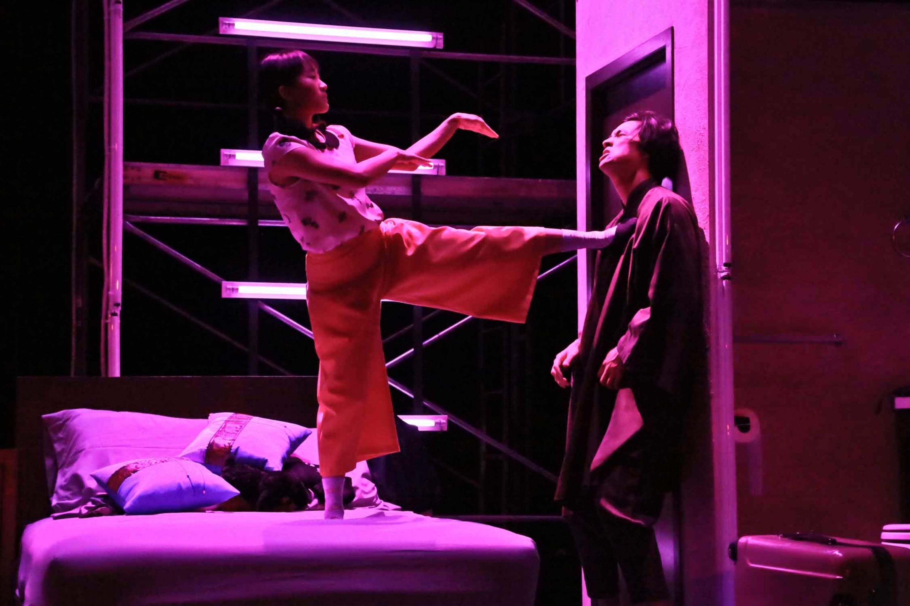 a woman forcefully positions her foot at a man's head