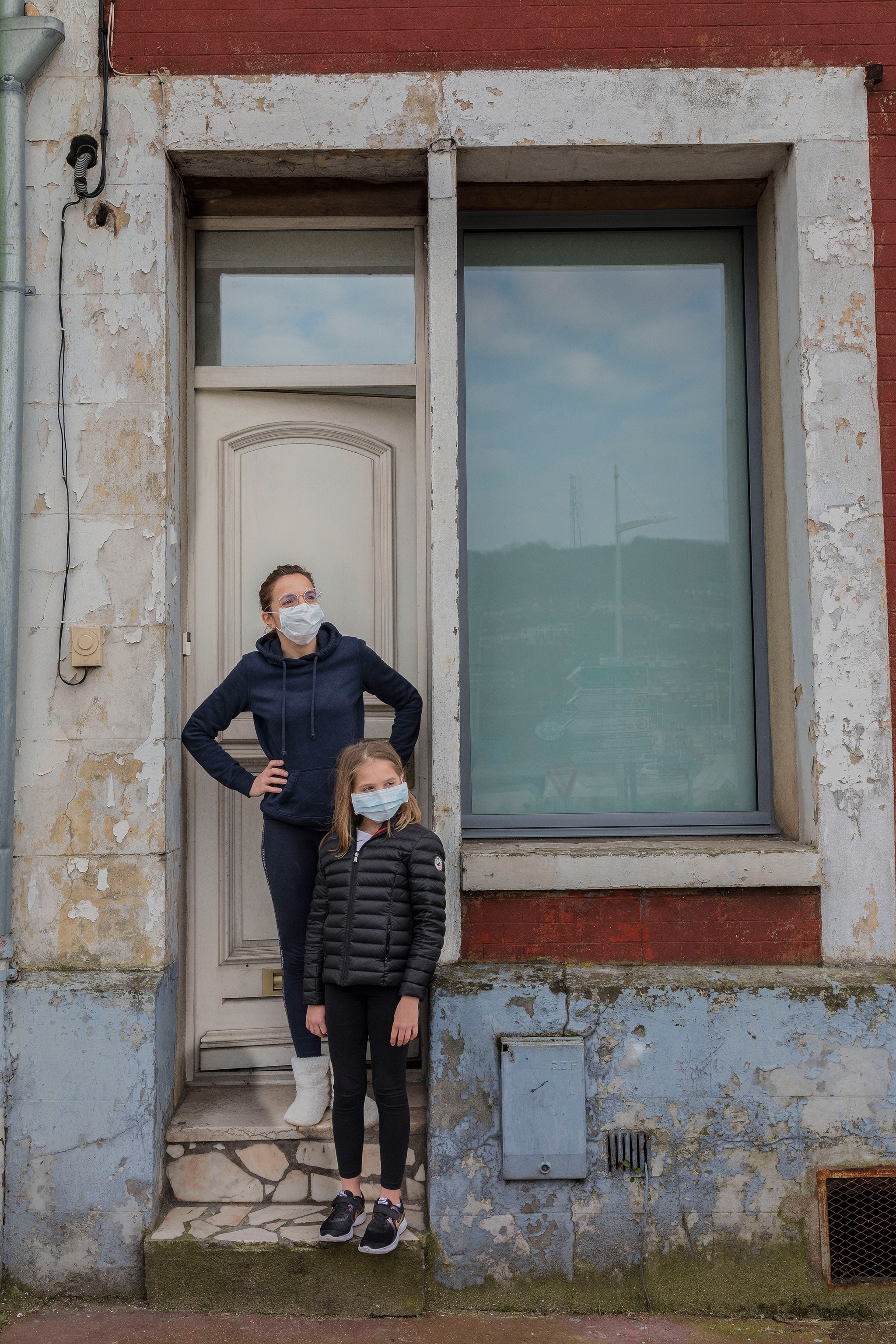people wearing masks stand outside a building