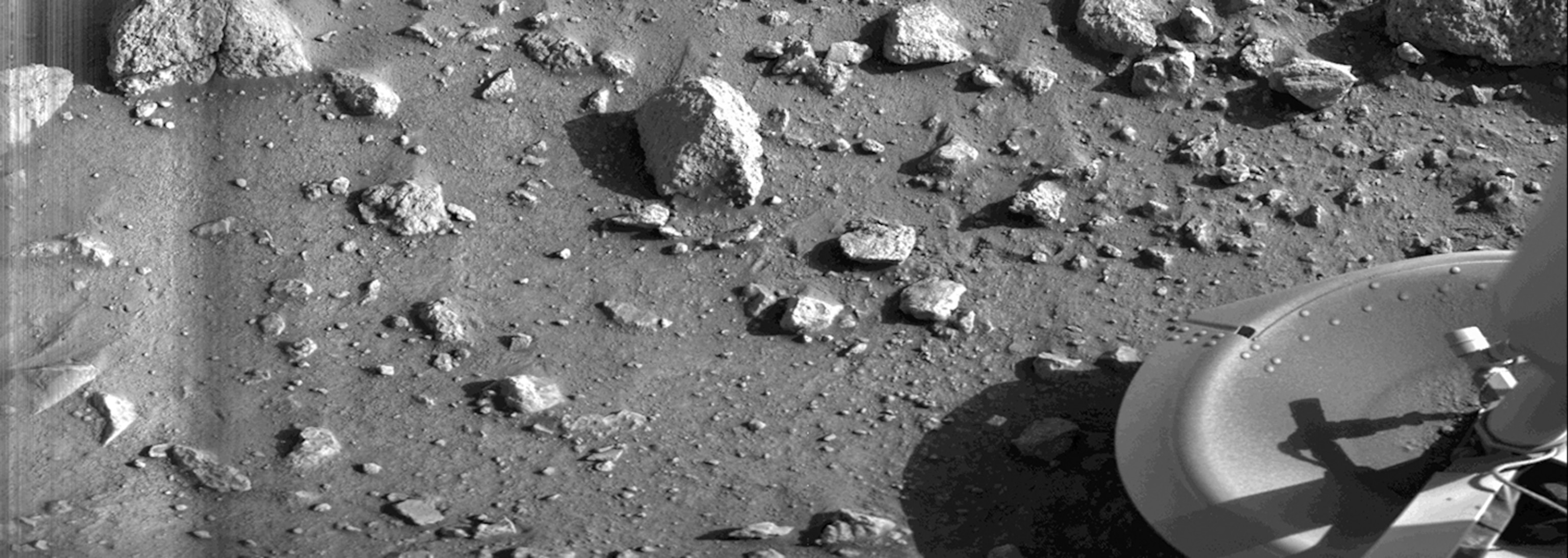hi-res b&w photo of Mars surface with visible part part of rover