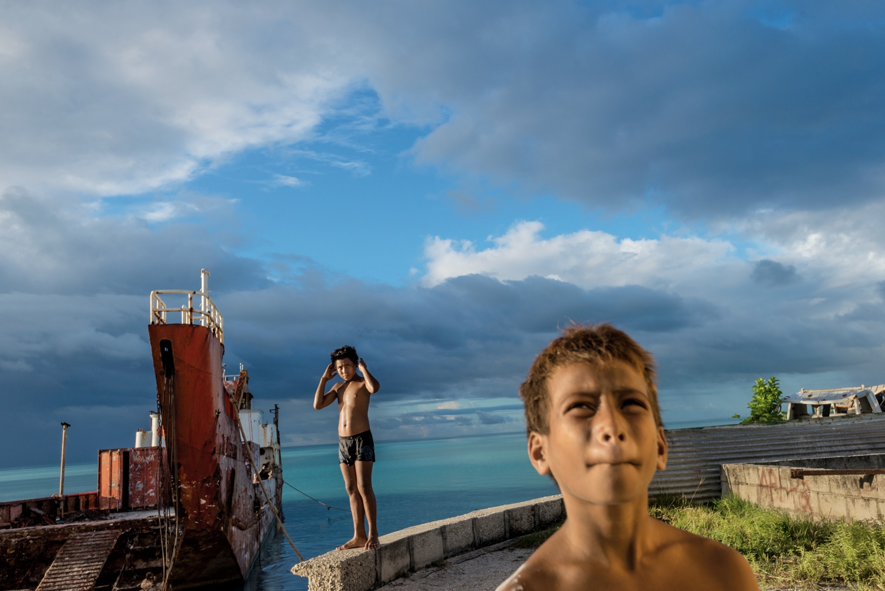 boys on a seawall in Kiribati