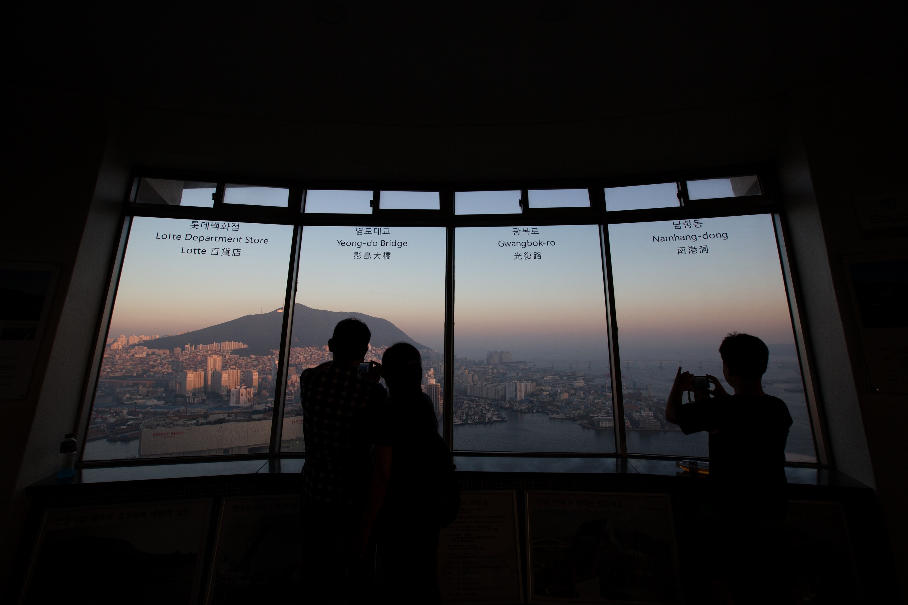 The silhouettes of visitors are seen as they look at the city skyline at an observation deck in Busan, South Kore