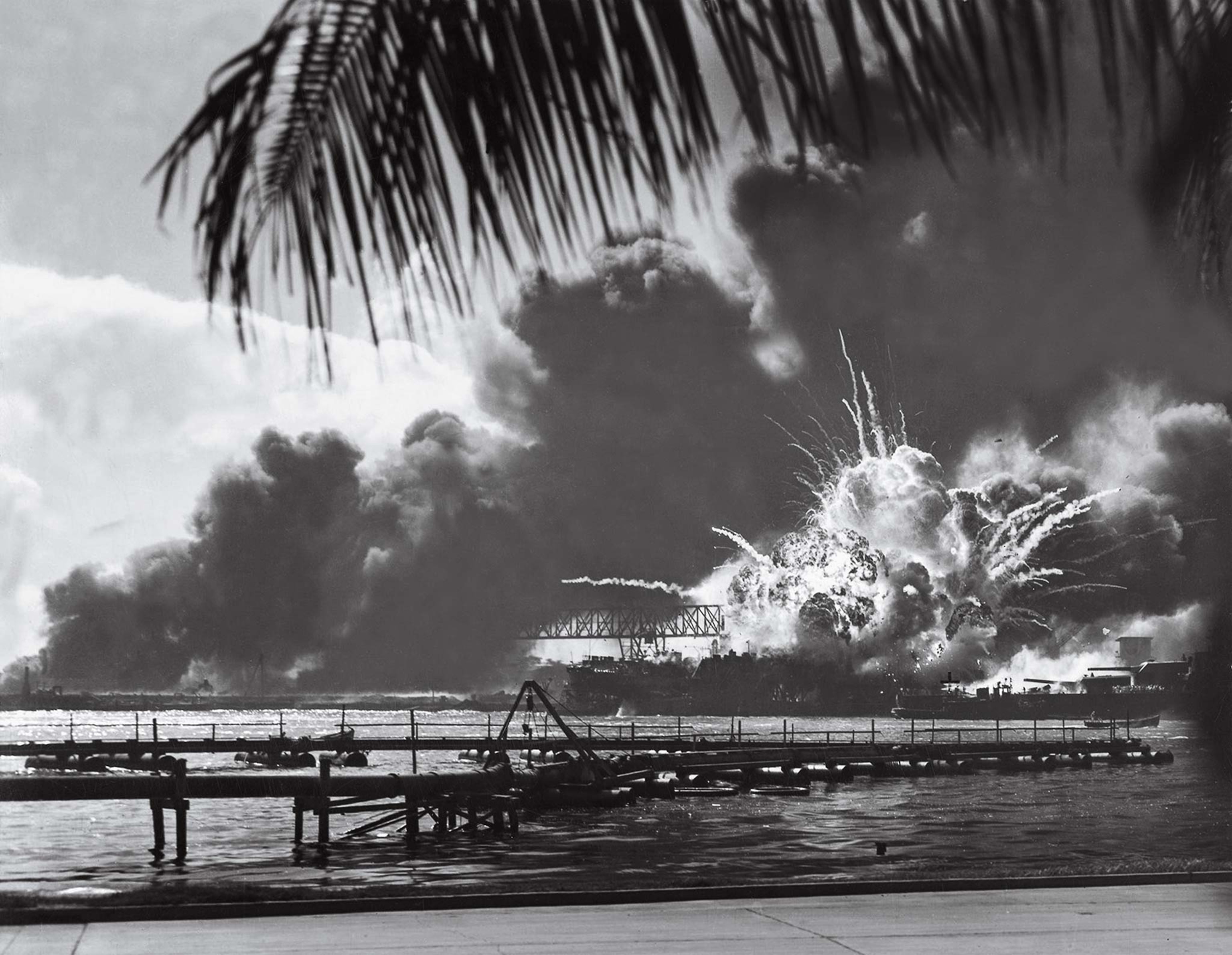 The U.S.S. Shaw explodes during the Japanese attack on Pearl Harbor in a black-and-white photo