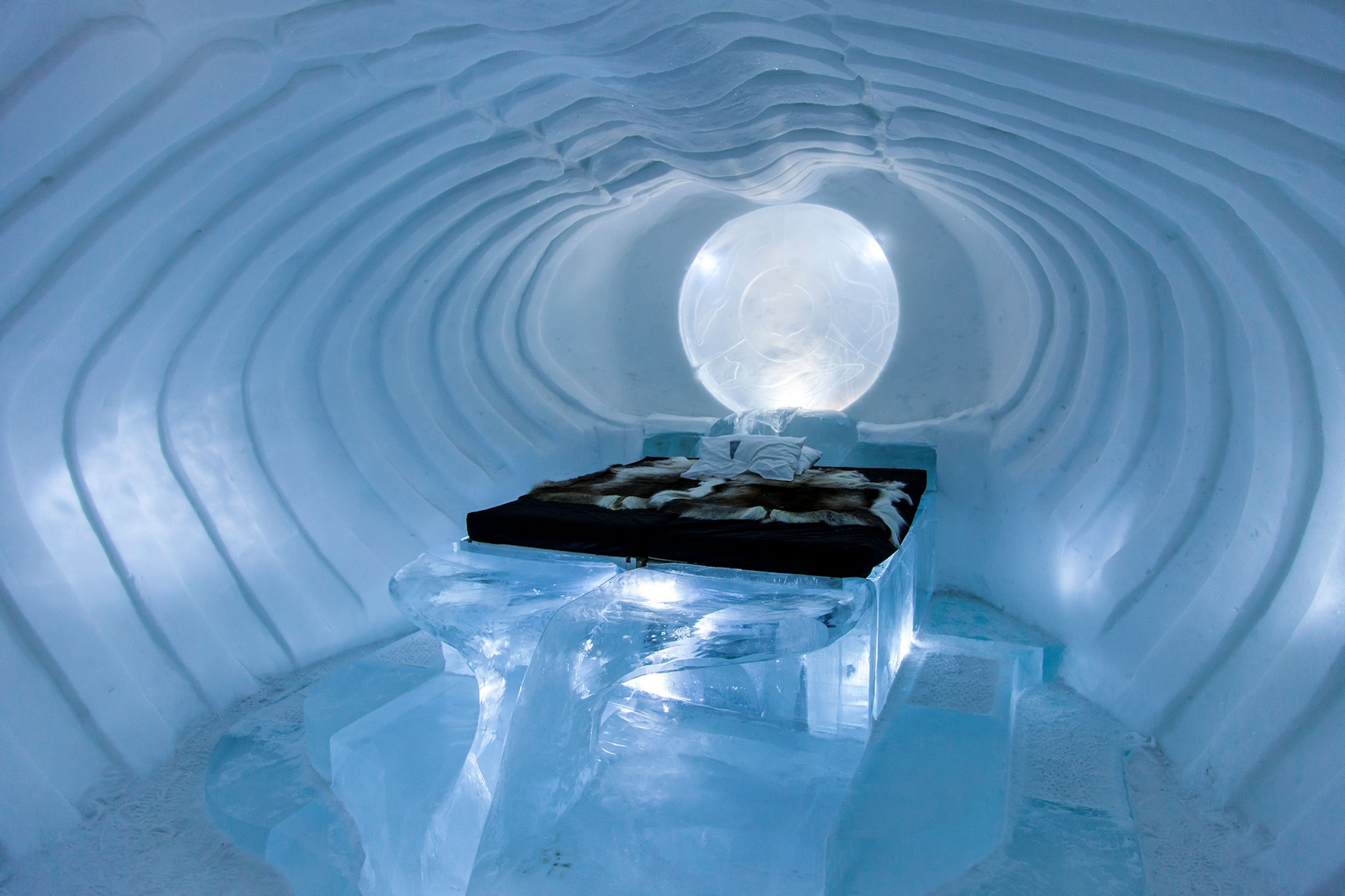 an room in an ice hotel with fur blankets