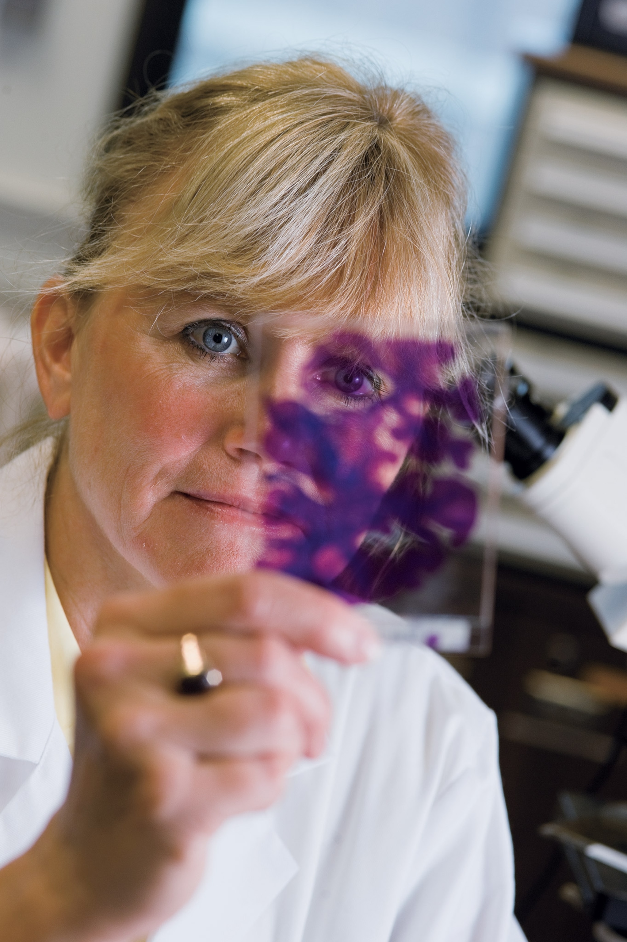 A woman holds a scan up looking at it.