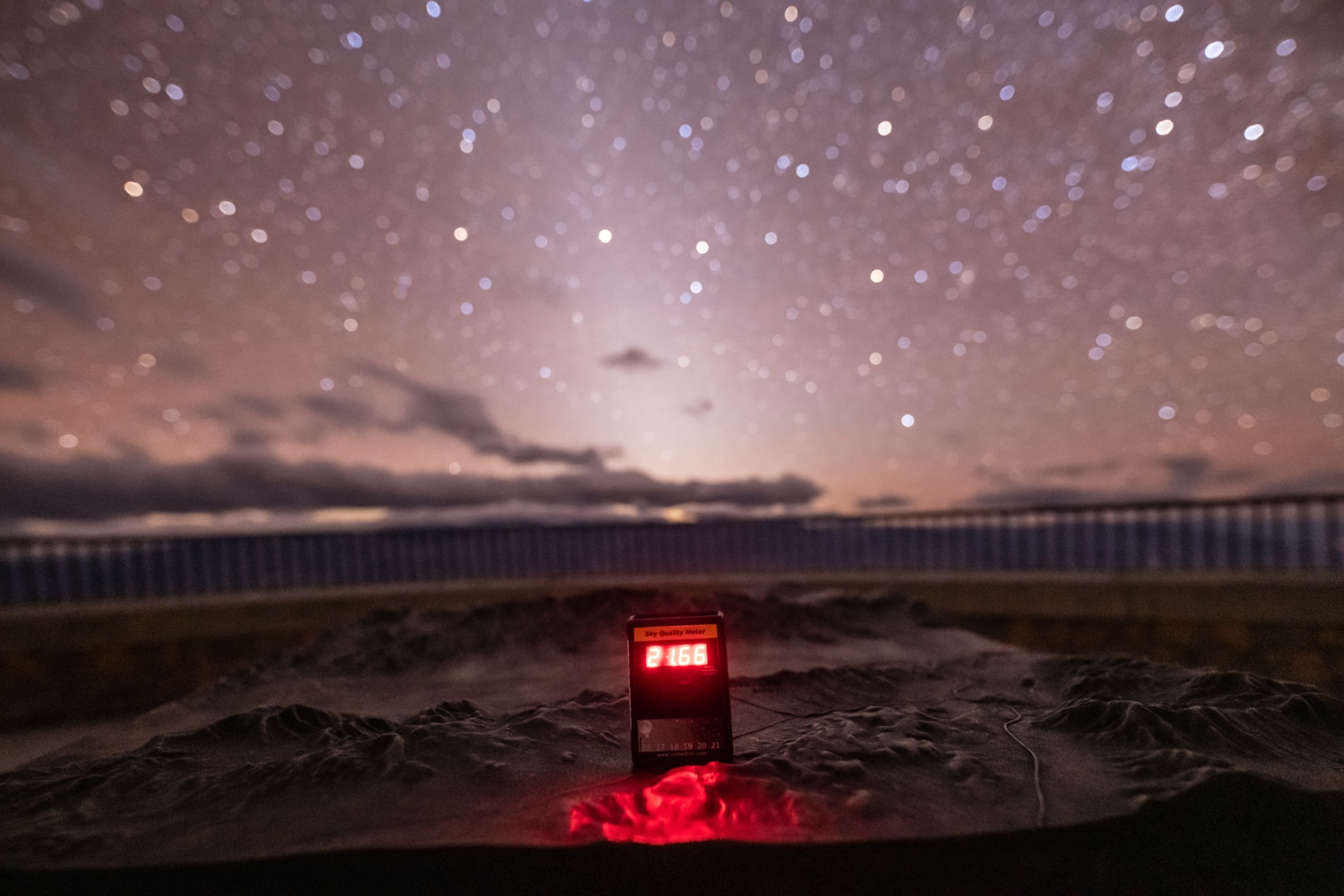 Beneath a starry sky, a Sky Quality Meter sits on the desert floor of Death Valley.