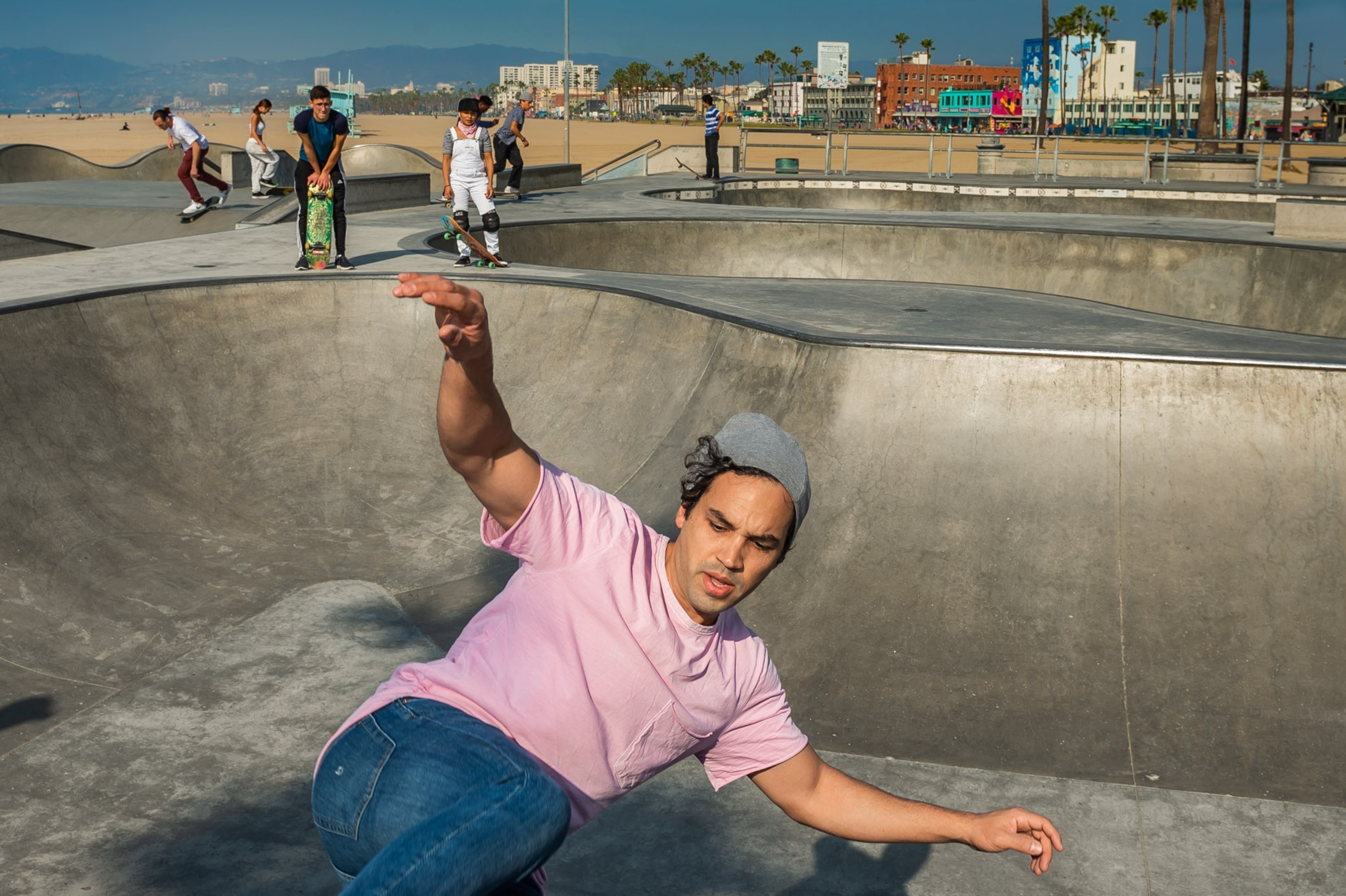 a man with his arms spread wide as he skates upward on a bowl