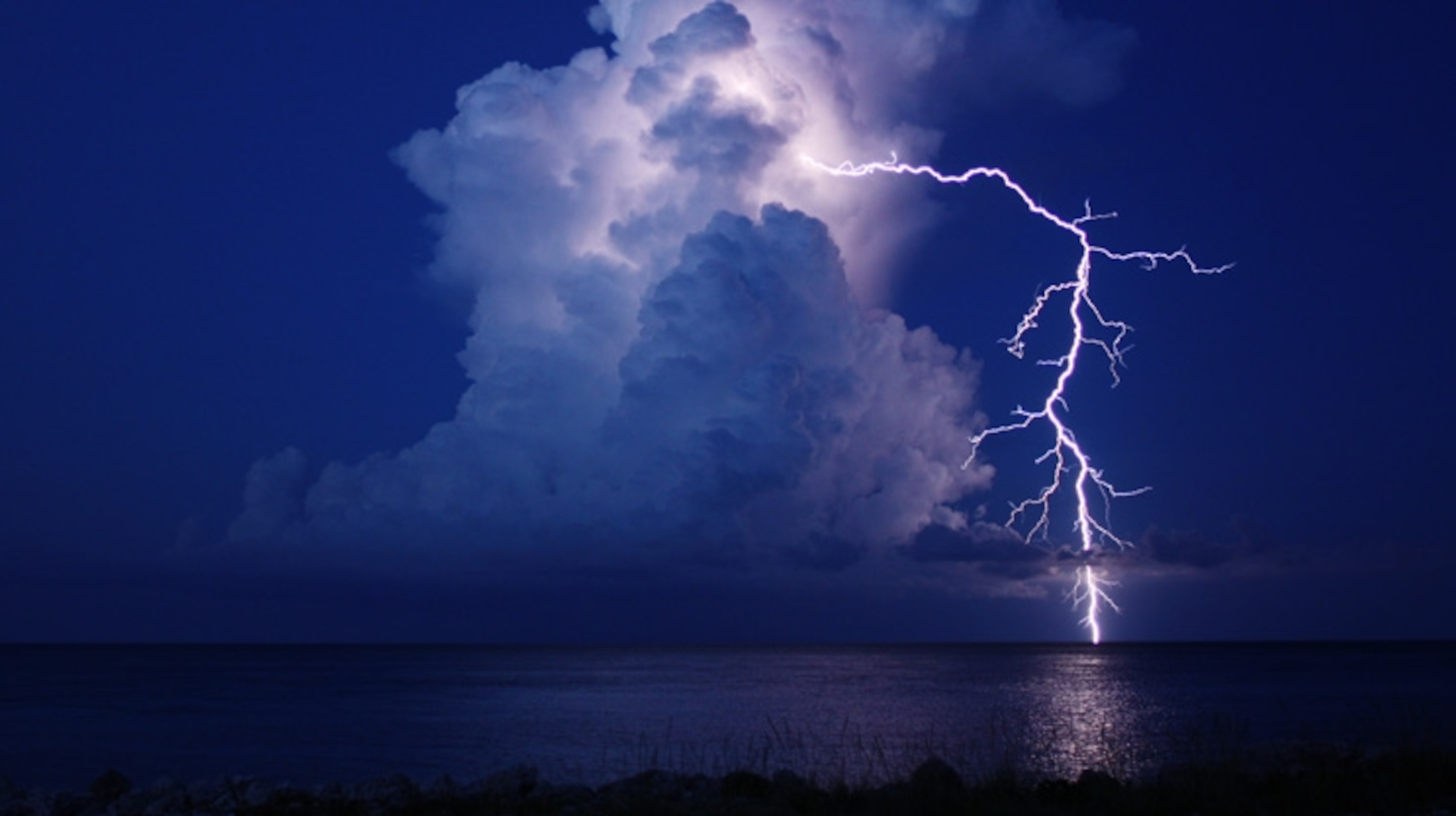 Lightning arcing from top of cloud to the horizon