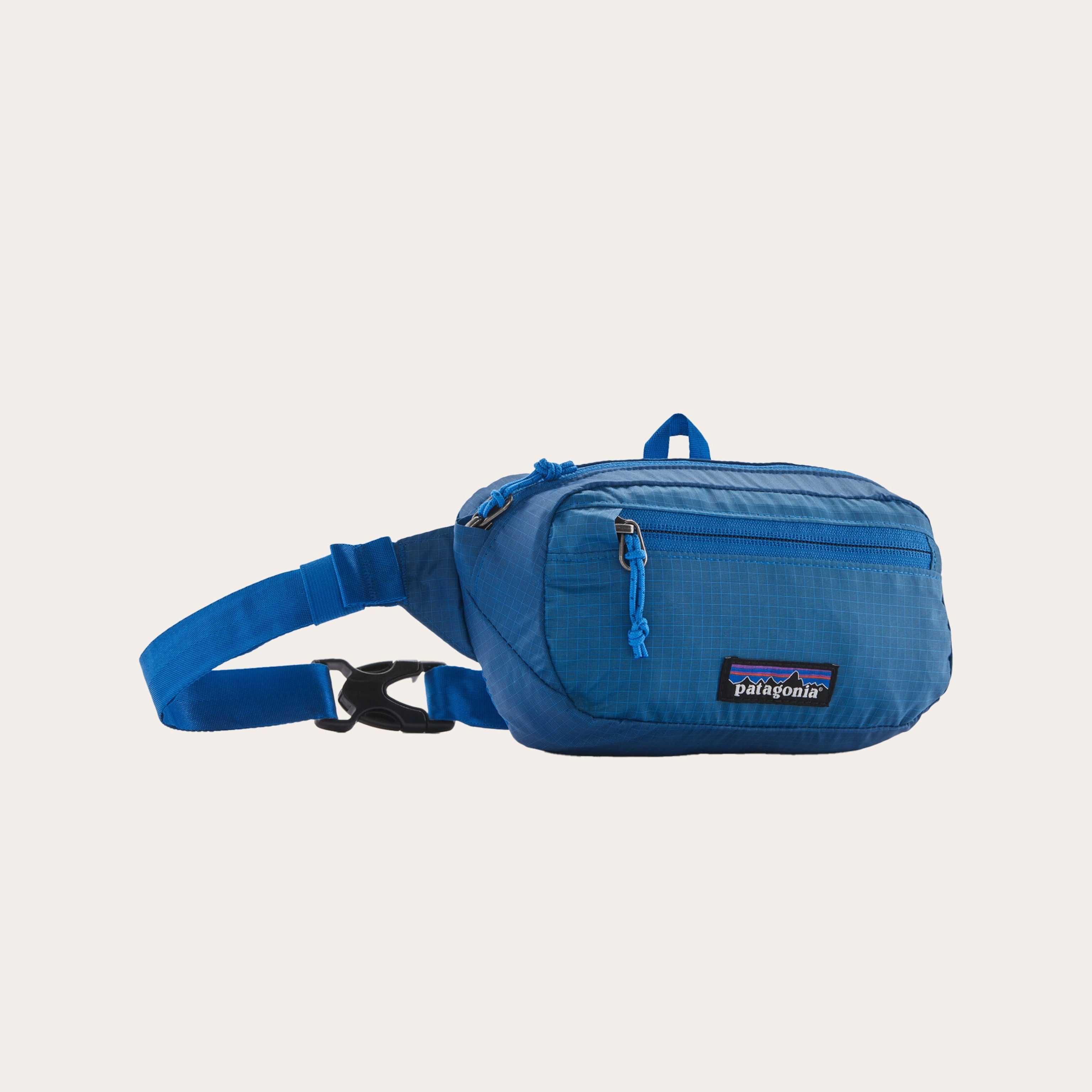 Blue fanny pack bag placed on a tan background
