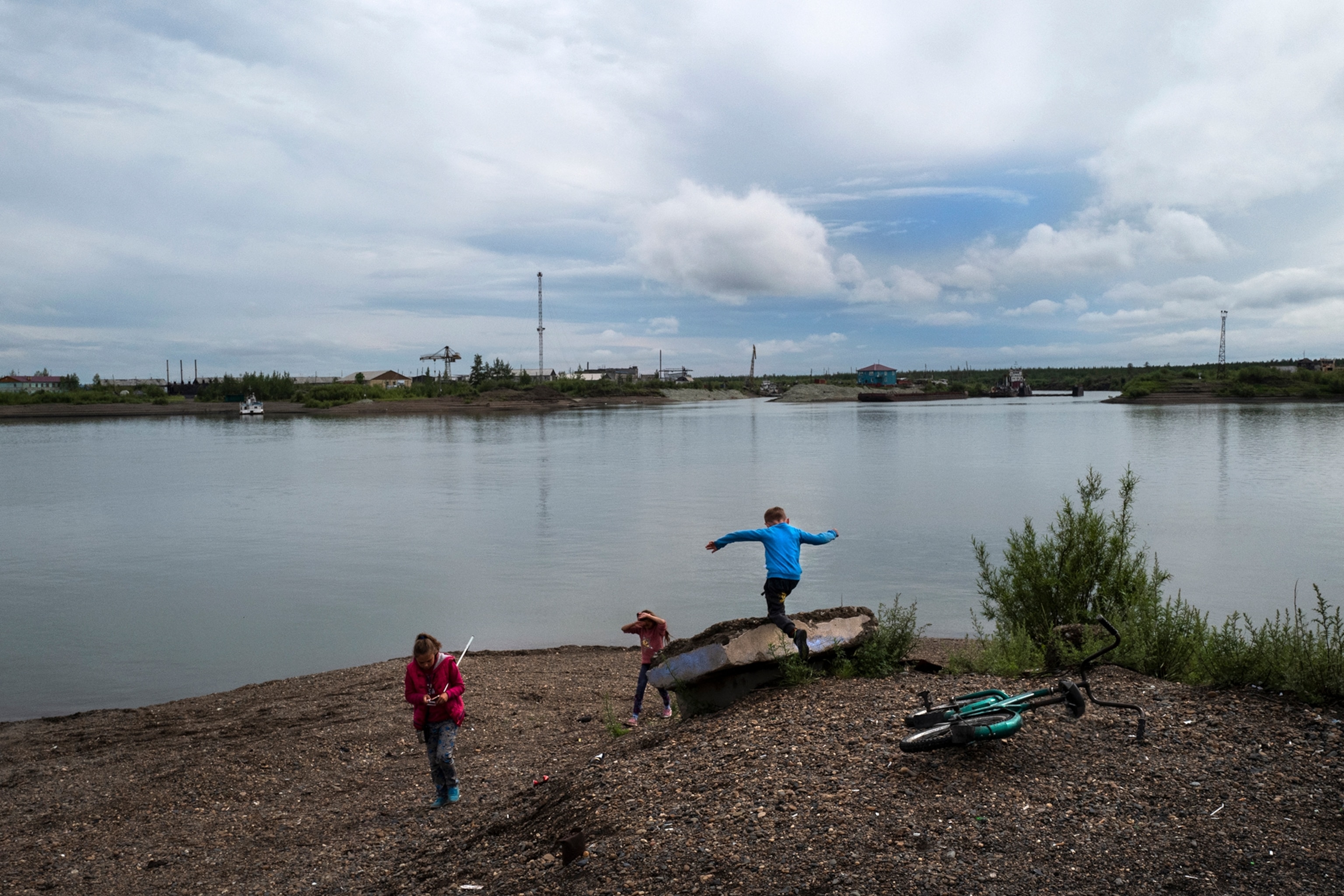 children playing next to a river just below the siberian arctic circle
