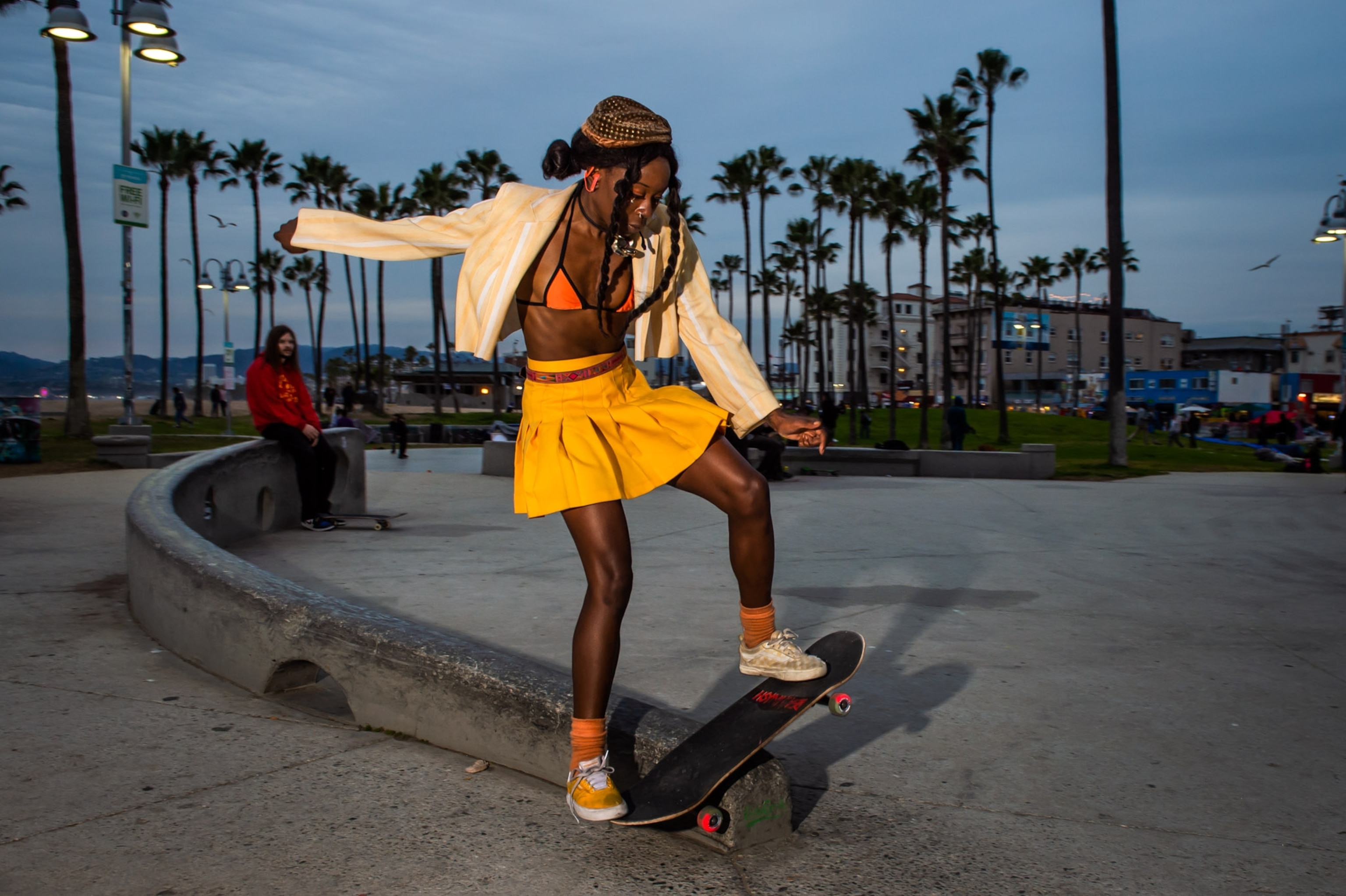 a girl in a bright yellow skirt skating around dusk
