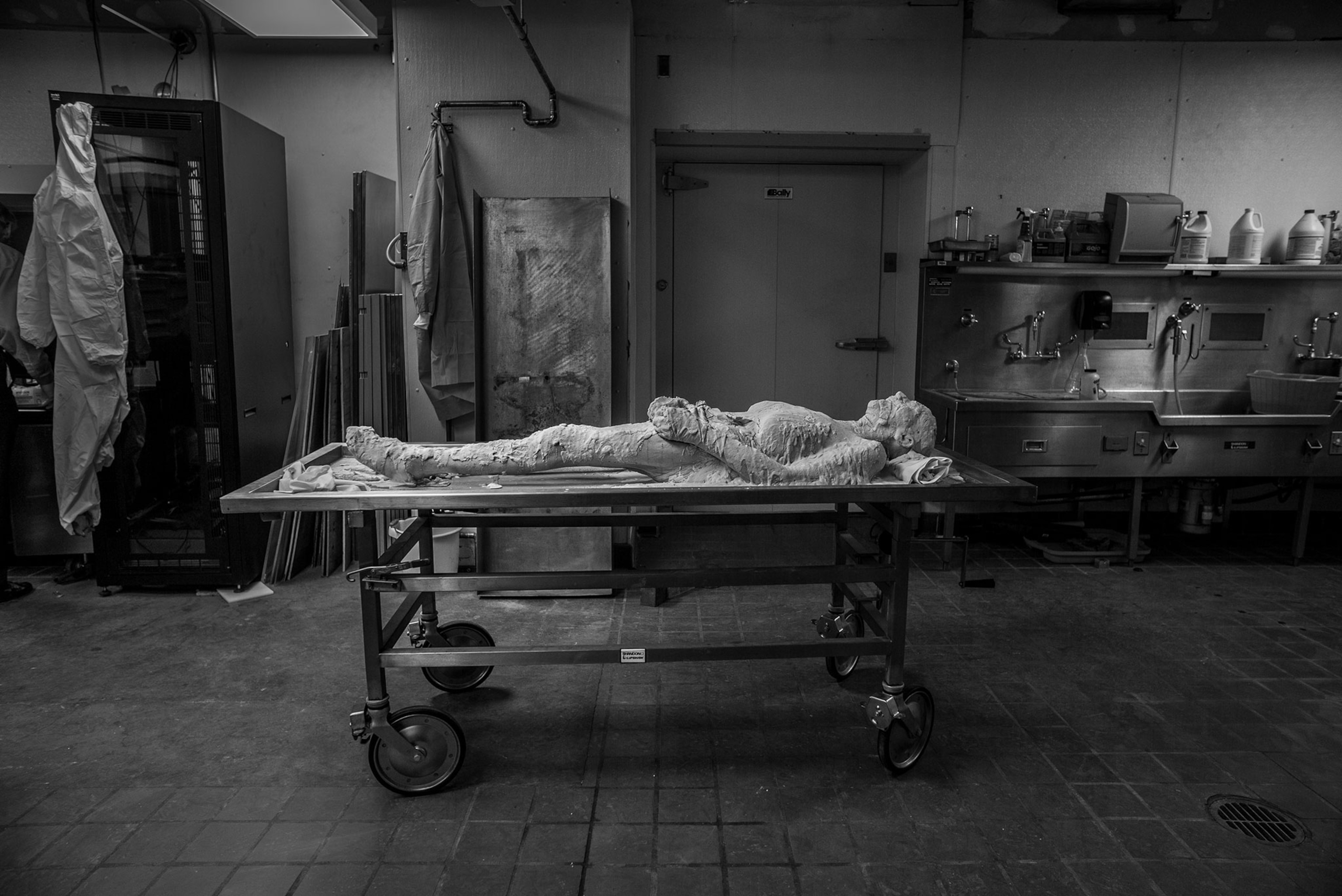 A body coated in polyvinyl alcohol on a table with wheels in a room