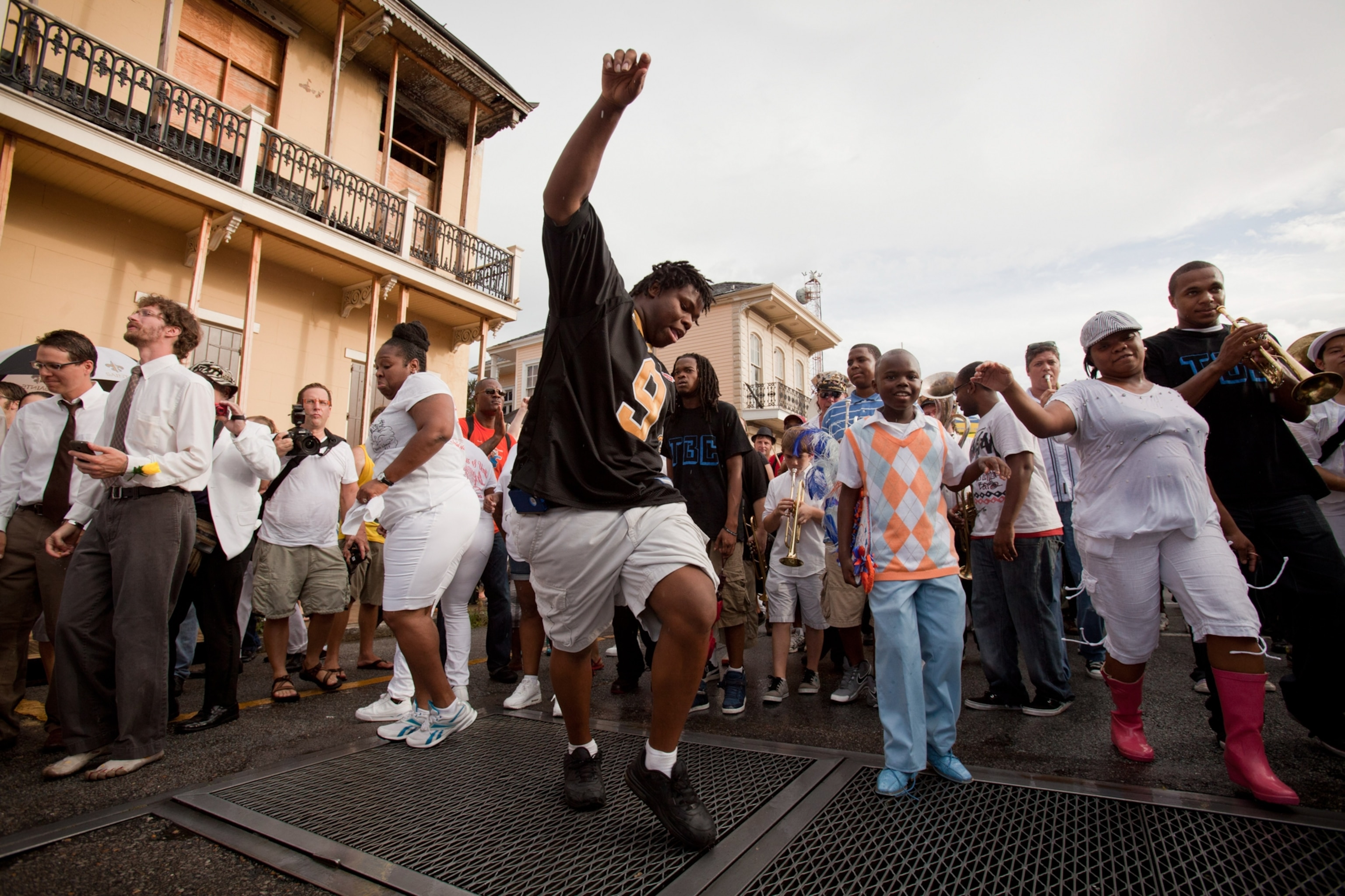 A young man dance with a crowde of people surrounding him.
