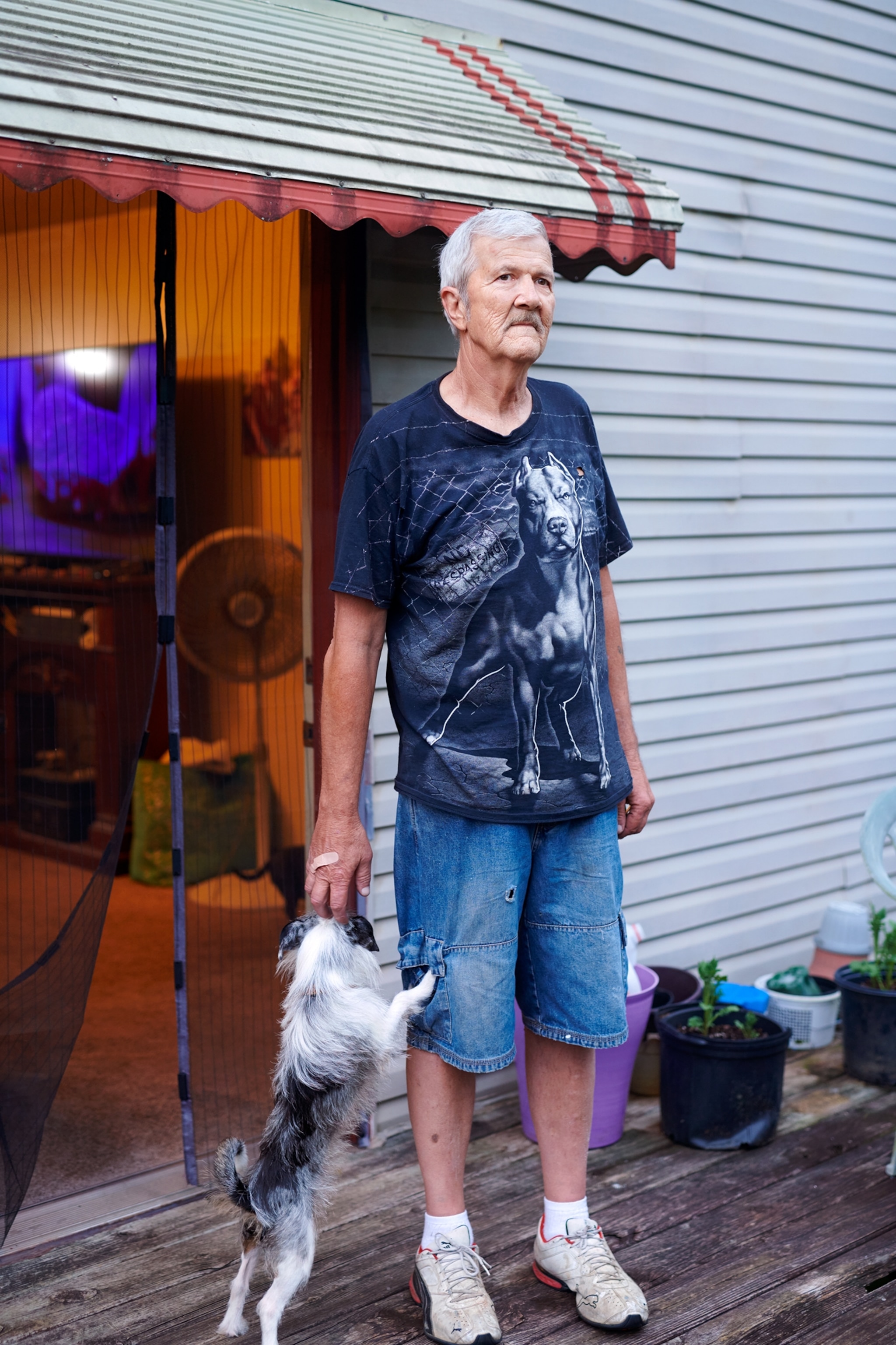 older man with a dog by sliding door.