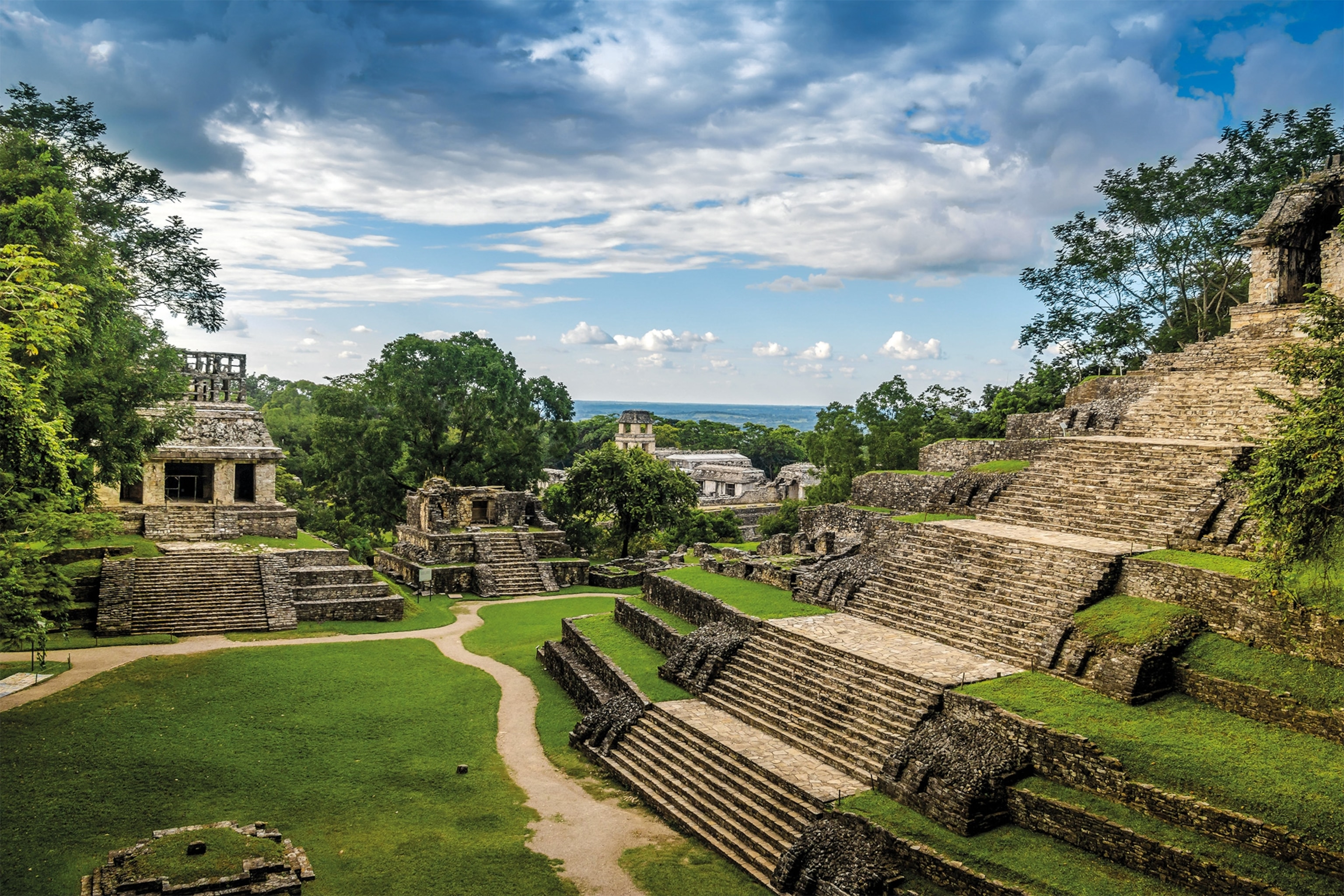 The steps leading up to the Temple of the Cross can be seen in the foreground. The Grand Palace and its tower rise in the background.