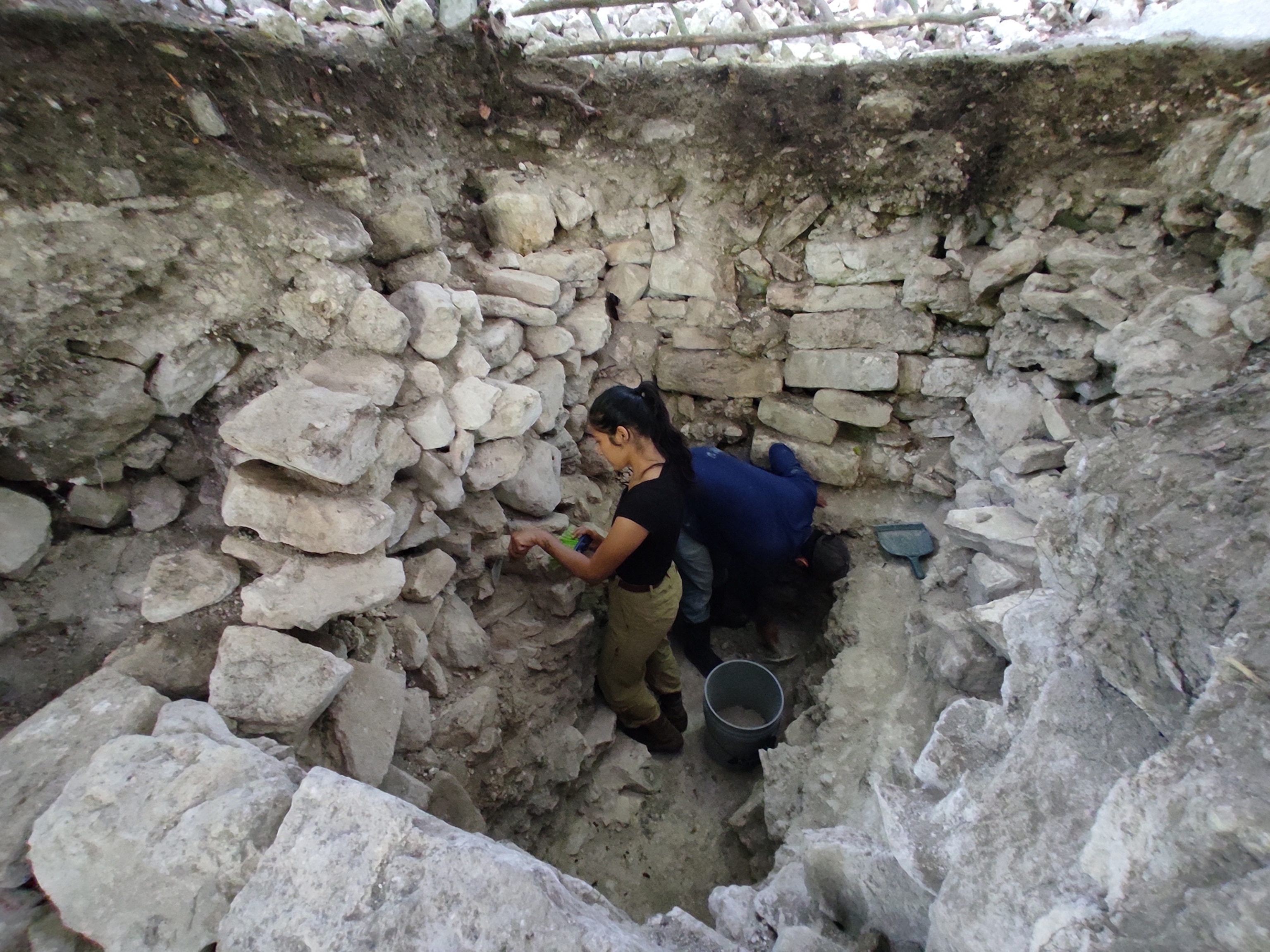 Excavations showing the construction fill in temple pyramid (Str. K-2) covering the burnt deposit of bones and royal ornaments at the site of Ucanal.