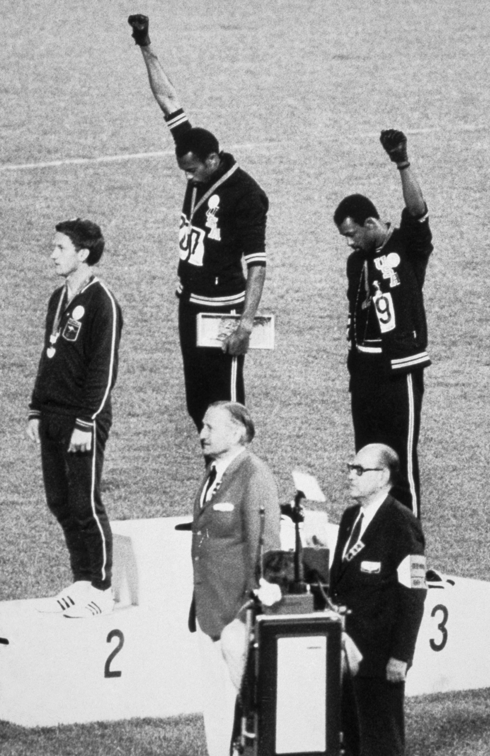 Olympic winners on the pedestal raising their fists