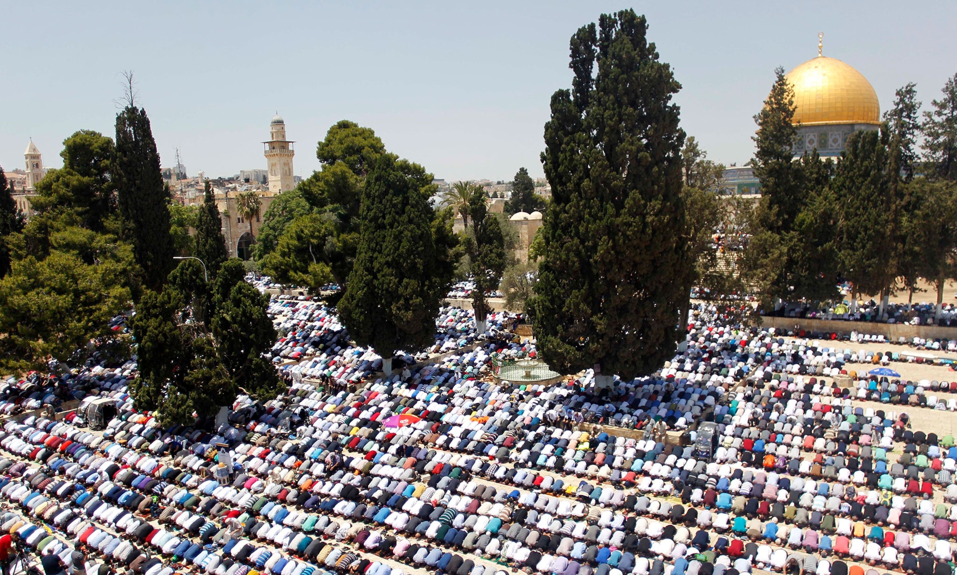 muslims praying outside near the Dome of the Rock.