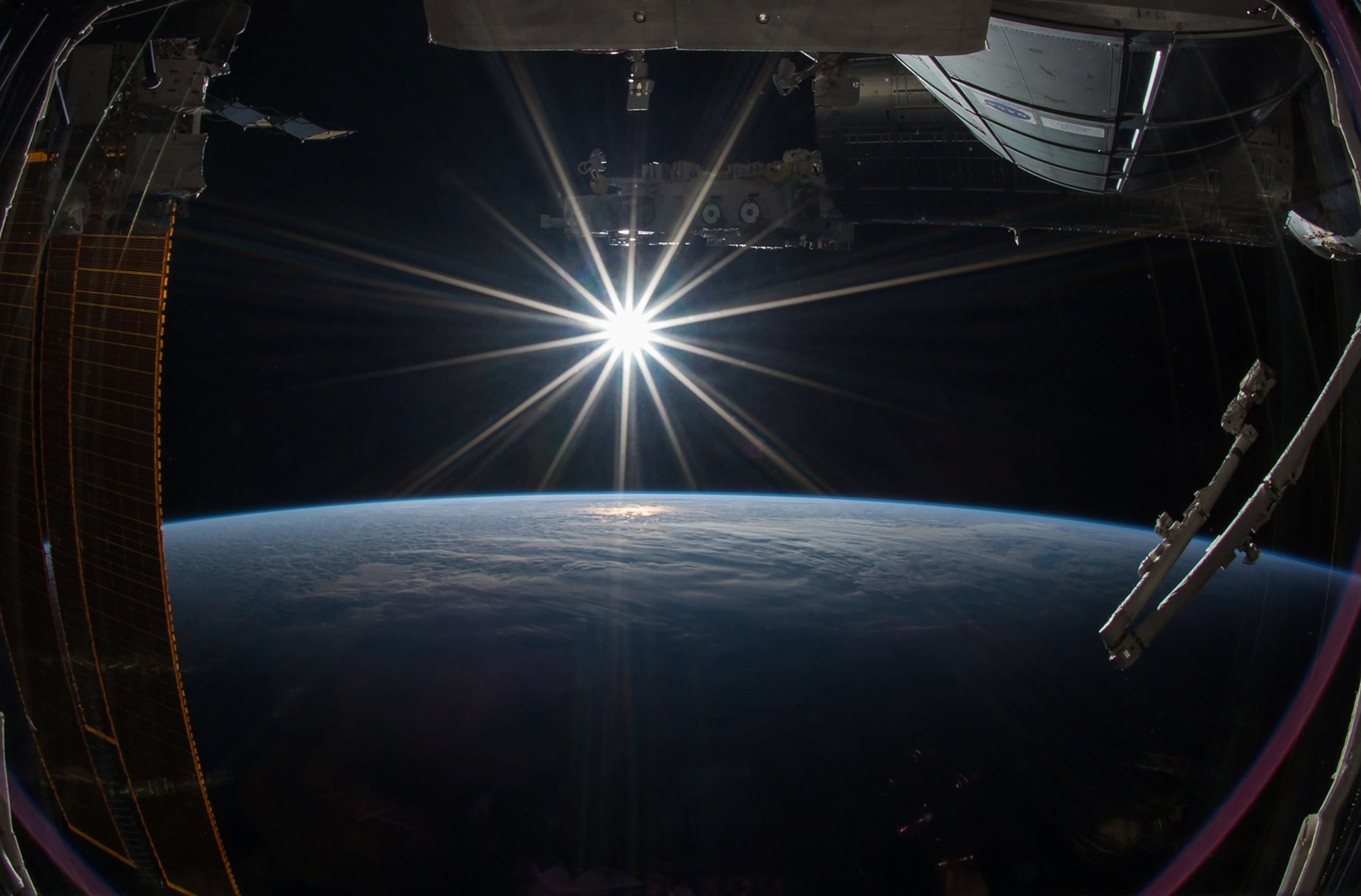 the Sun rising over Earth from the International Space Station.