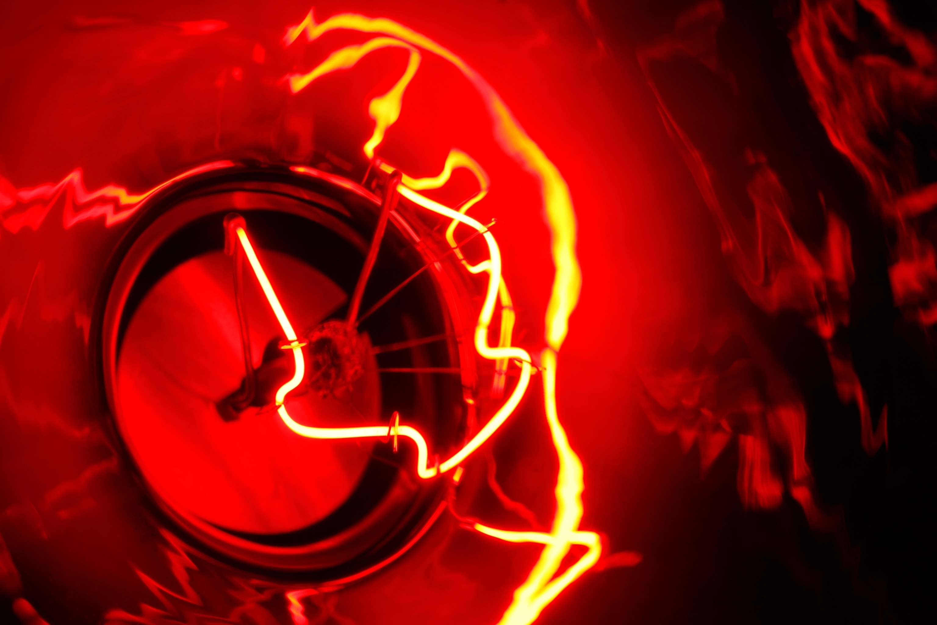A close-up view of a glowing red filament inside a lightbulb