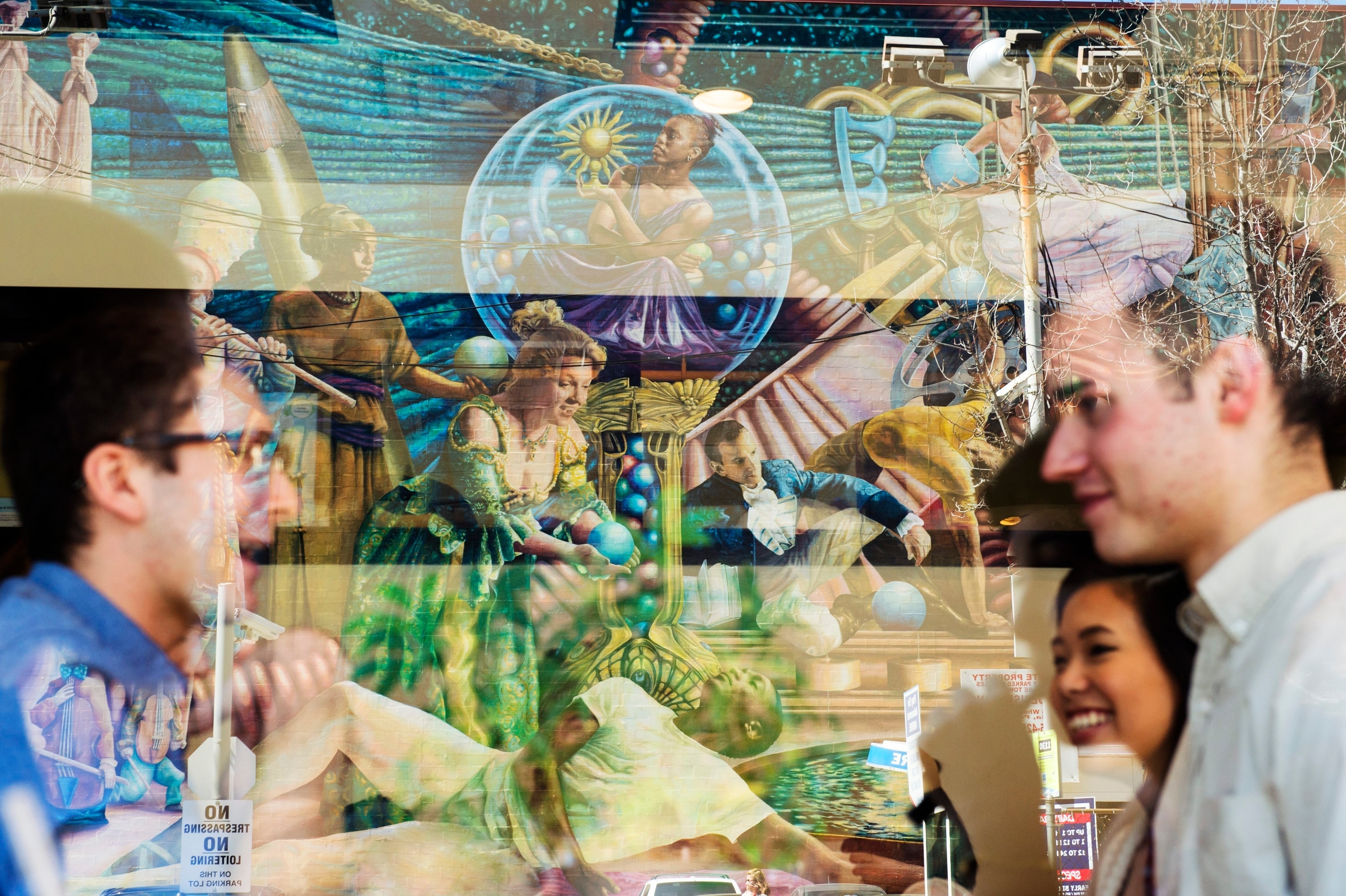 A reflection in a window of mural "Philadelphia Muses"