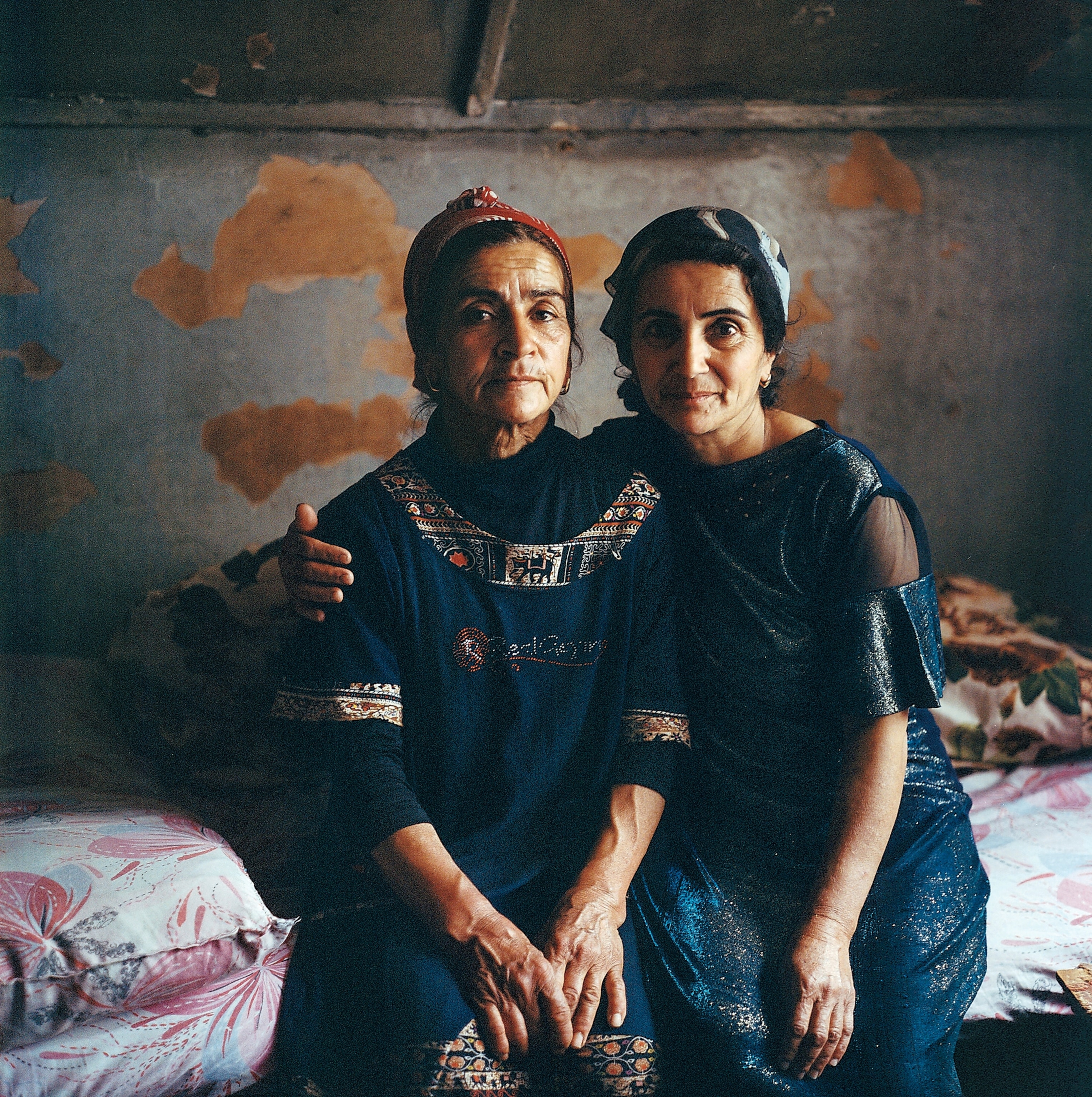 Two women sit together for a portrait.