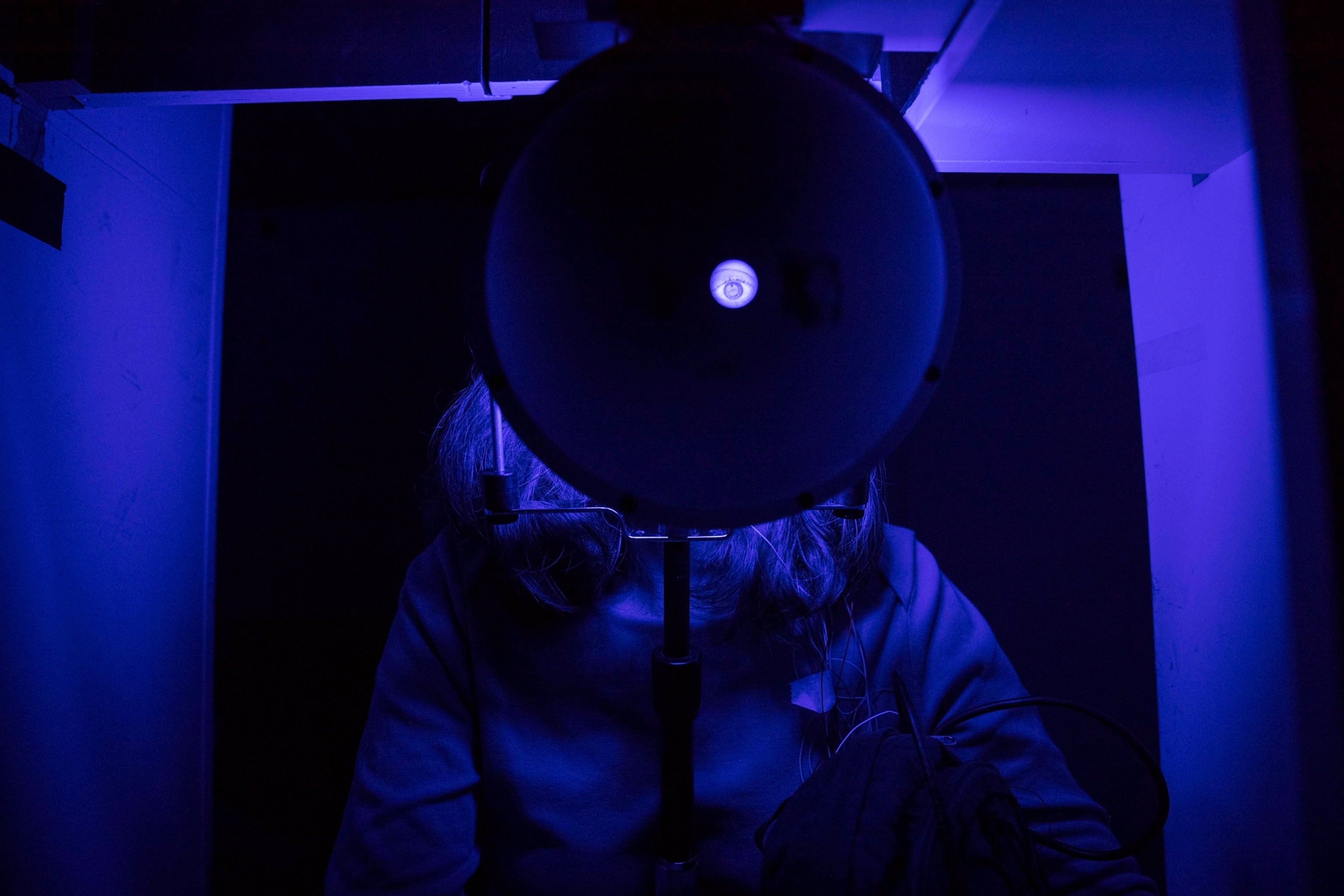 a circular machine with the eye showing through the machine cast in a blue light