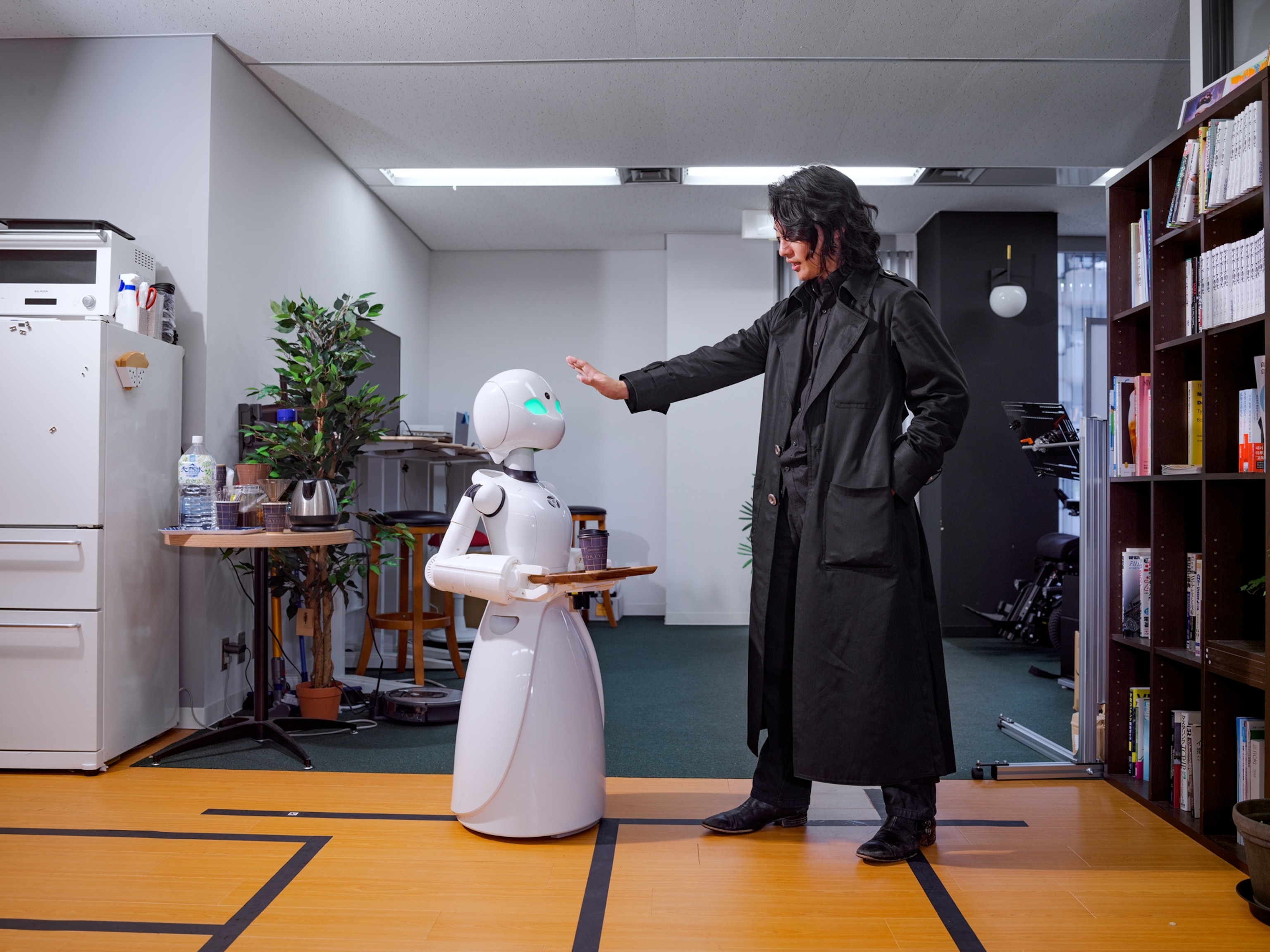 robot with white body holding a tray.