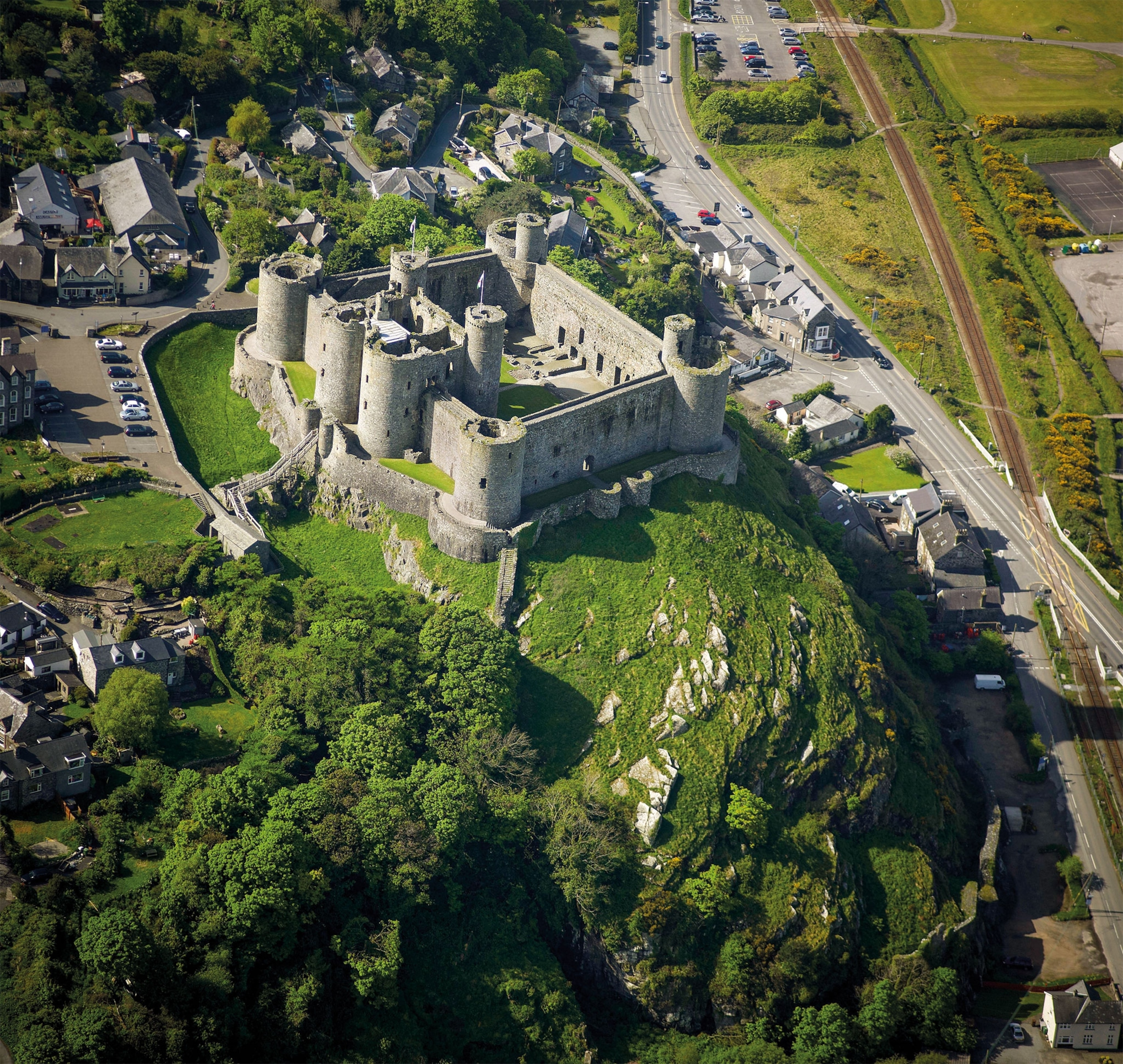 An aerial view of a medieval castle on a hill, surrounded by other modern buildings