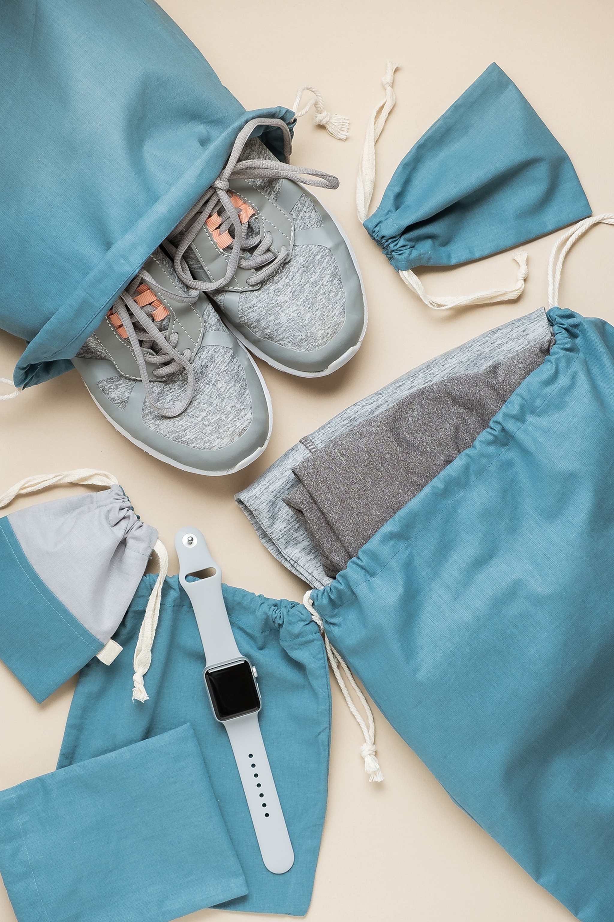Multiple small blue cloth bags for storing items including a pair of shoes.