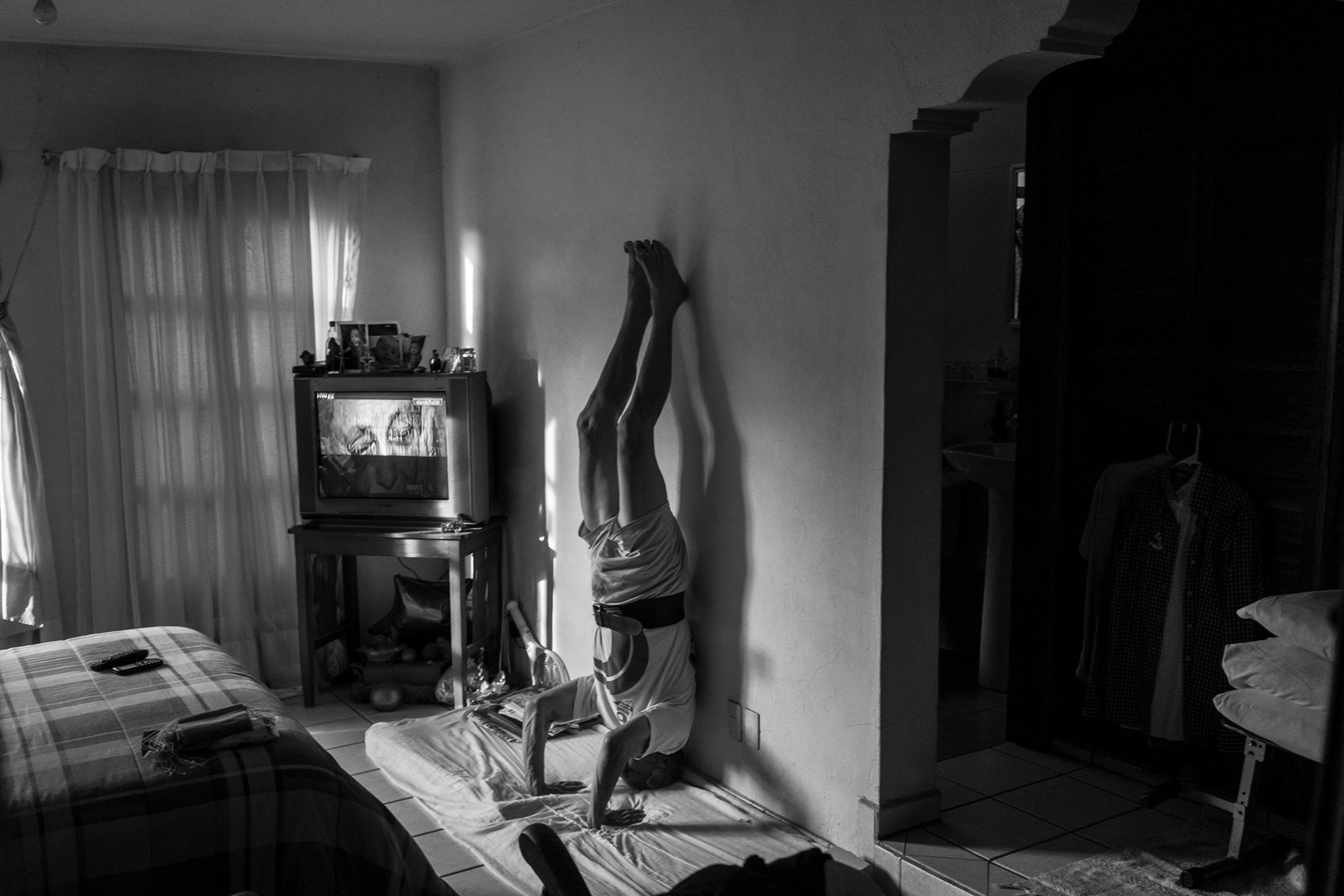 a person standing on his head against a wall