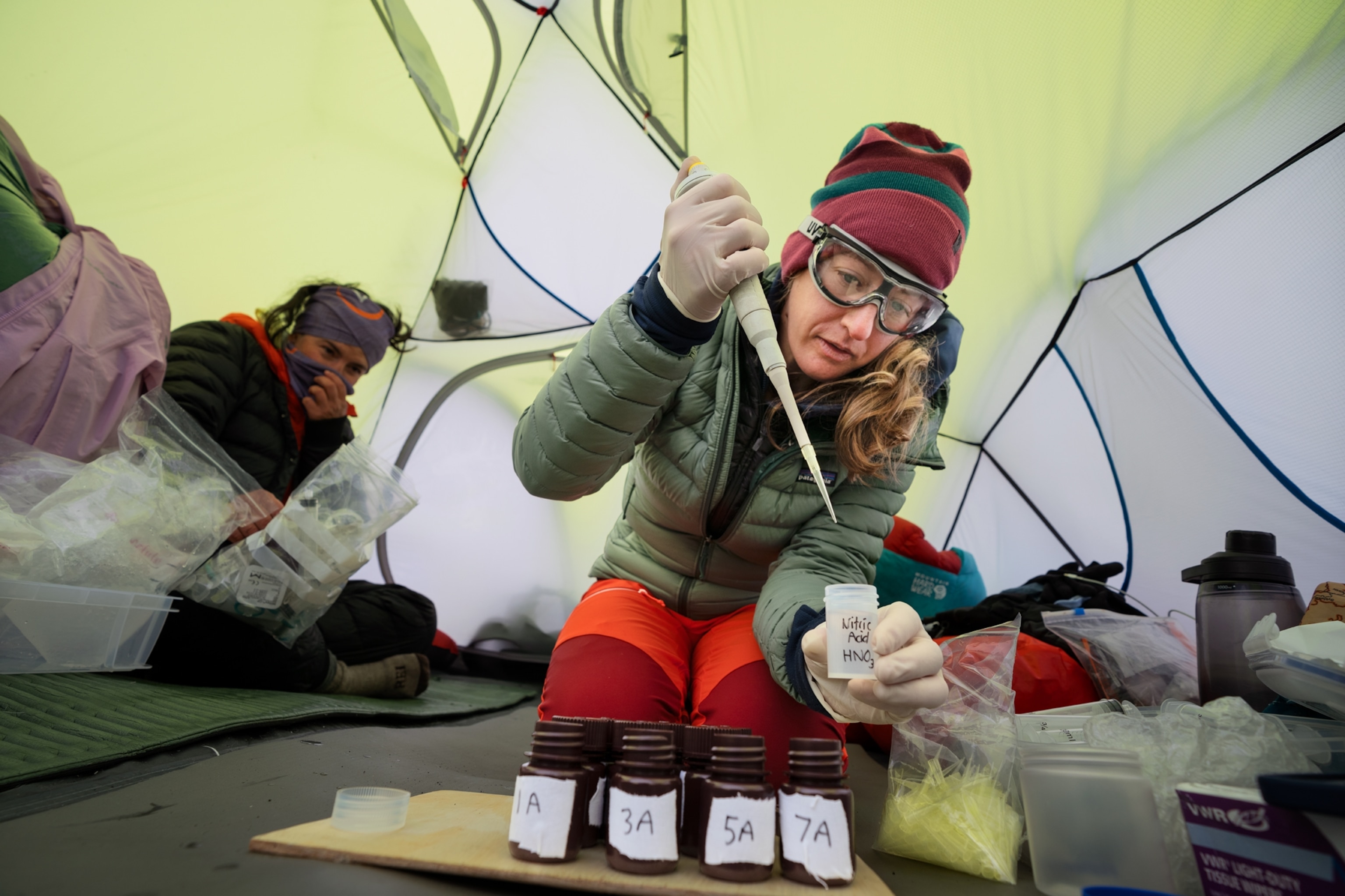 Woman adding drops of chemicals to the snow samples.