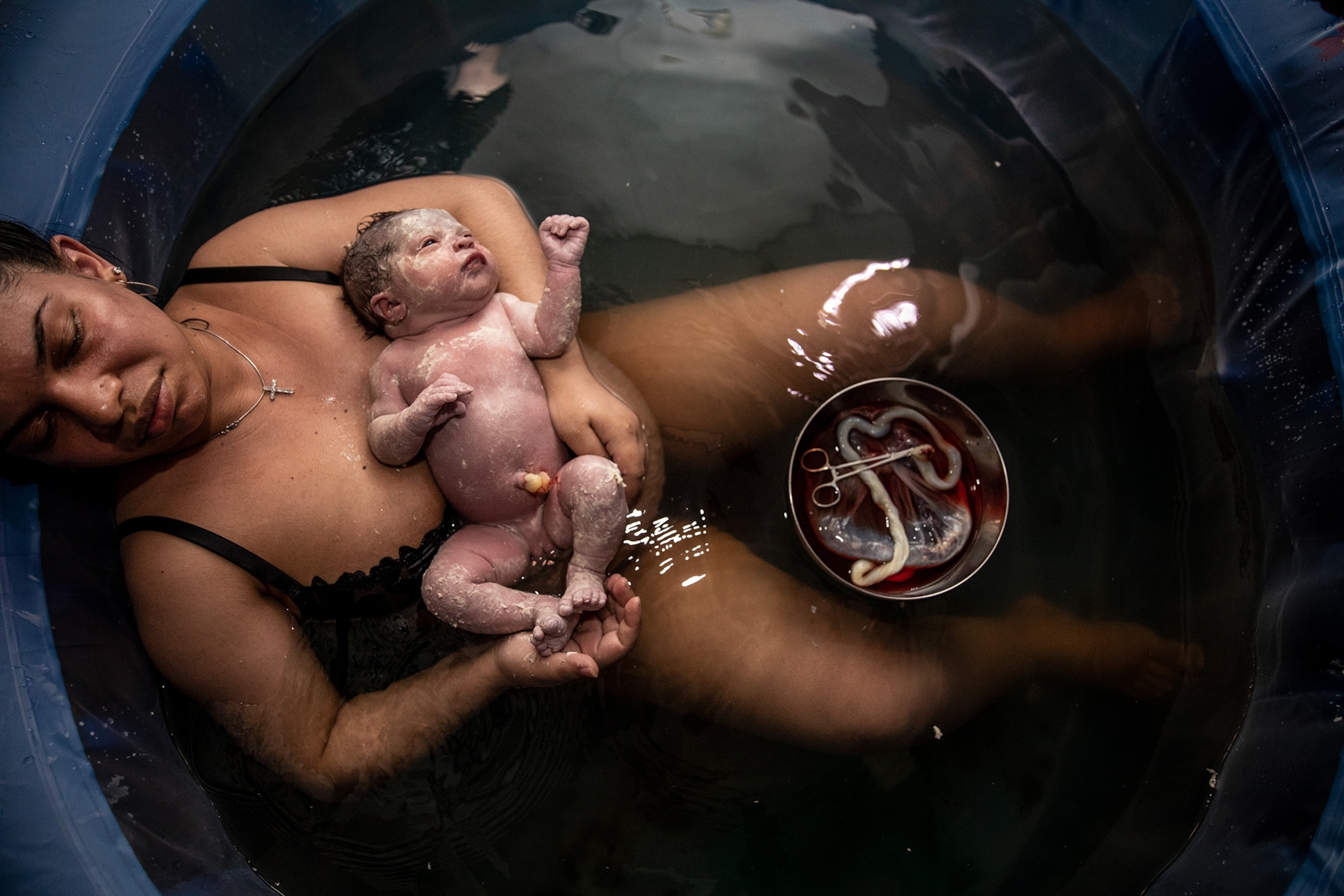 a woman holding her newborn baby after giving birth at home
