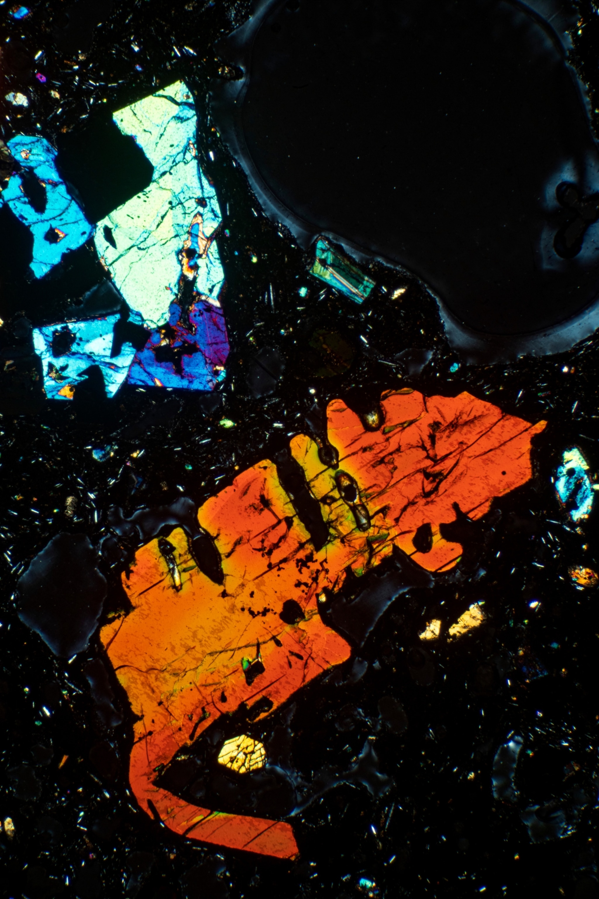 An irregularly shaped sample of amphibole, which appears red and yellow.