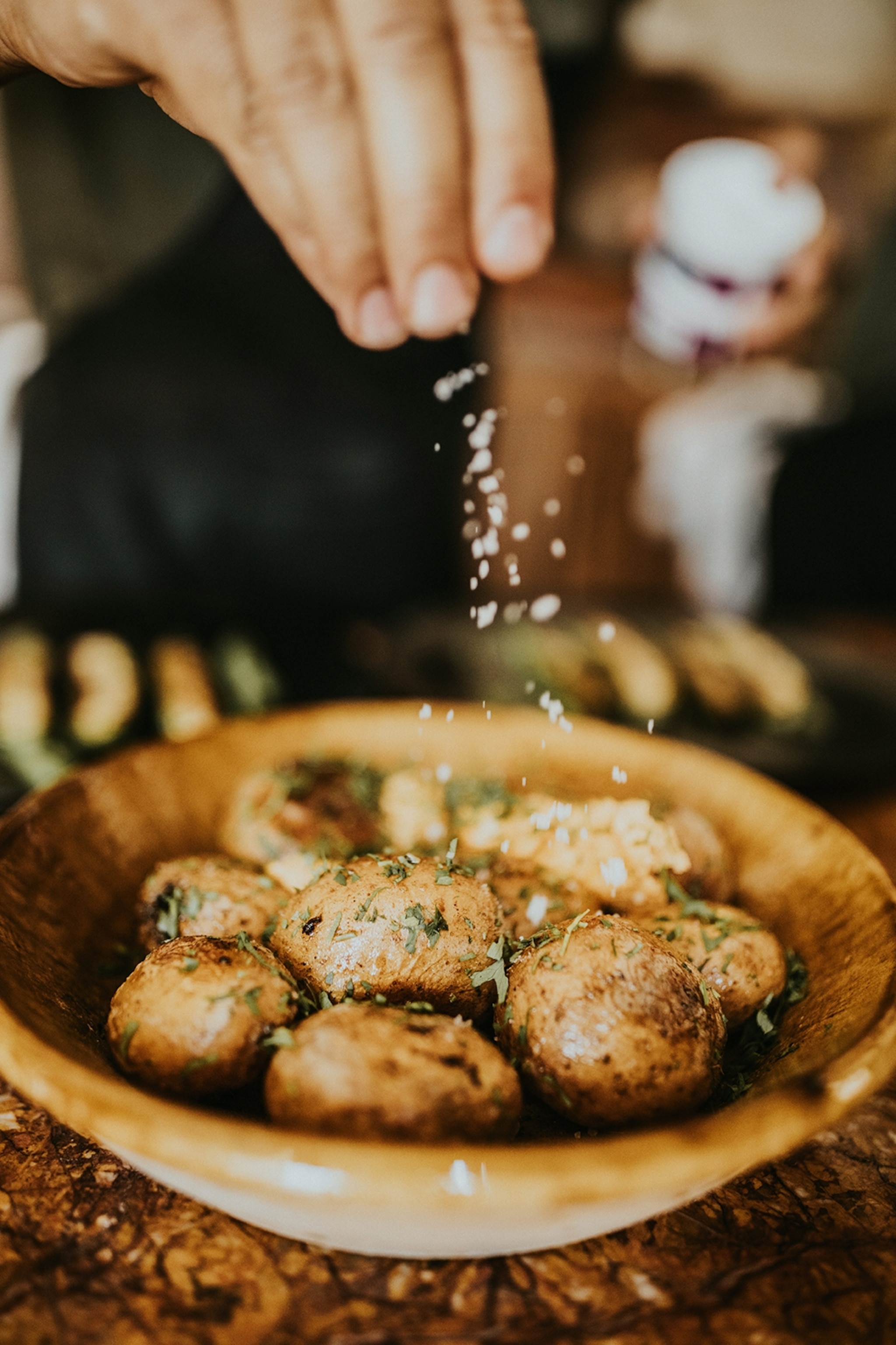 Sprinkling salt on a bowl of potatoes