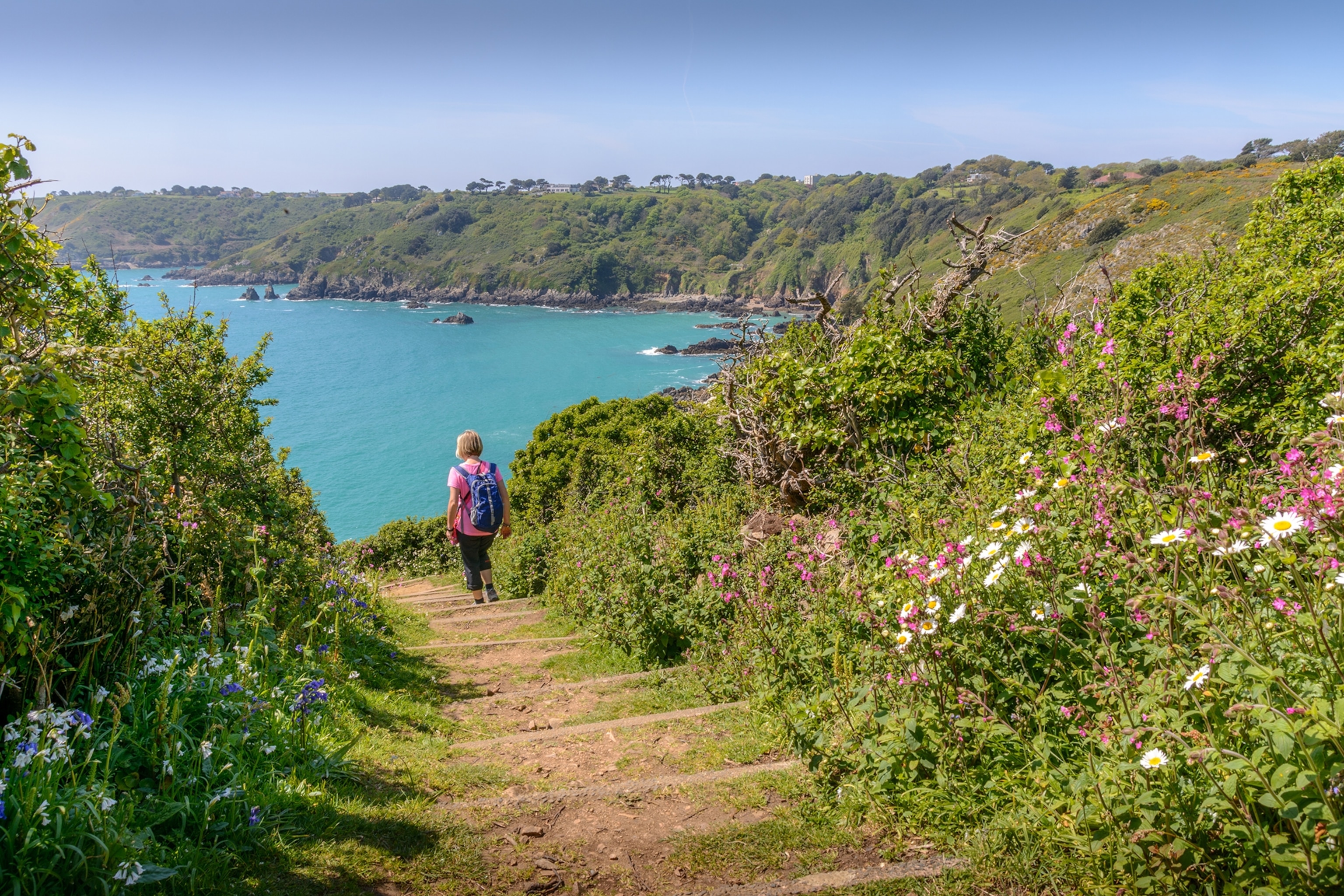 Rear View Of Woman Walking On Steps Towards Sea At Beach
