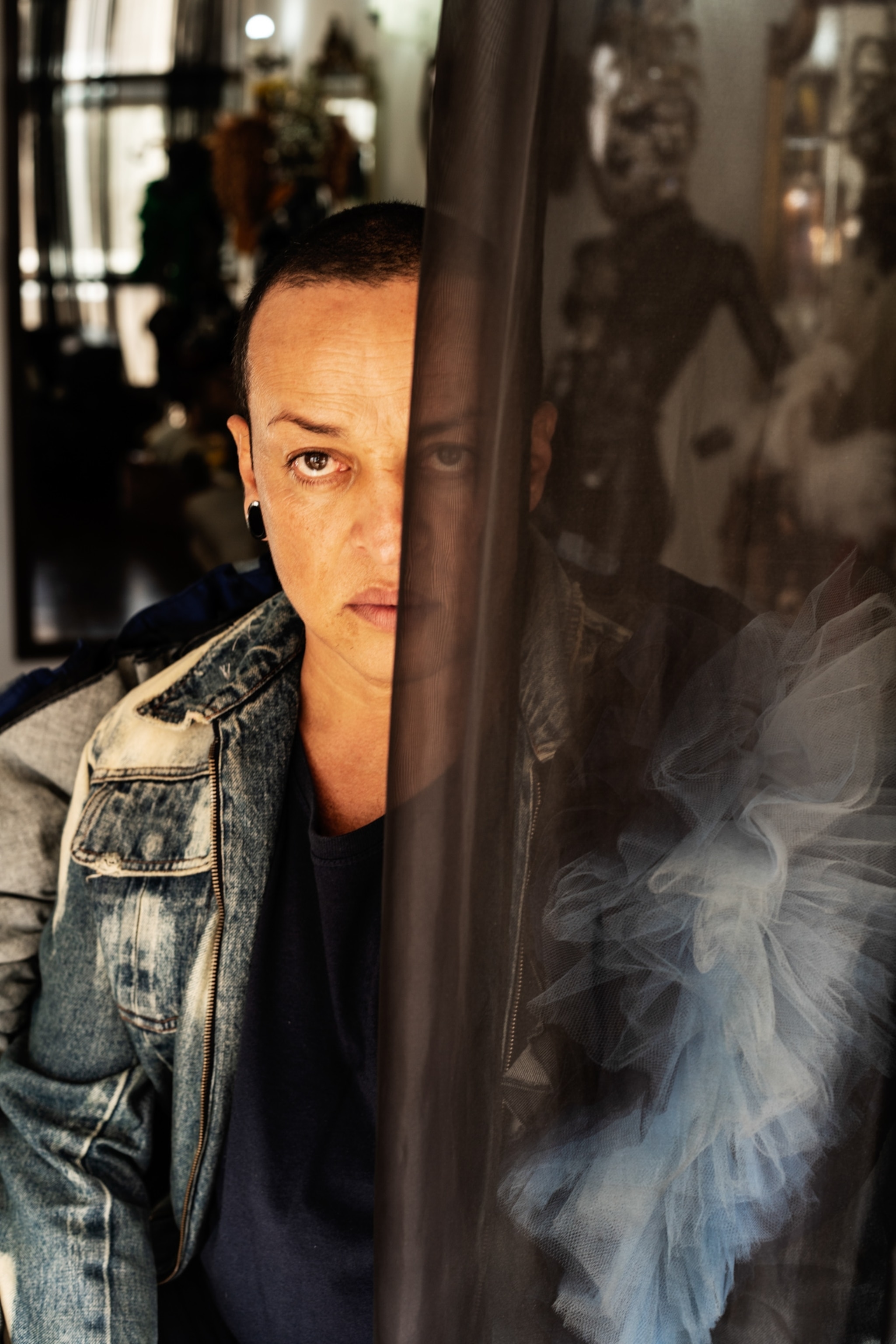 a man with have of his face behind a sheer cloth