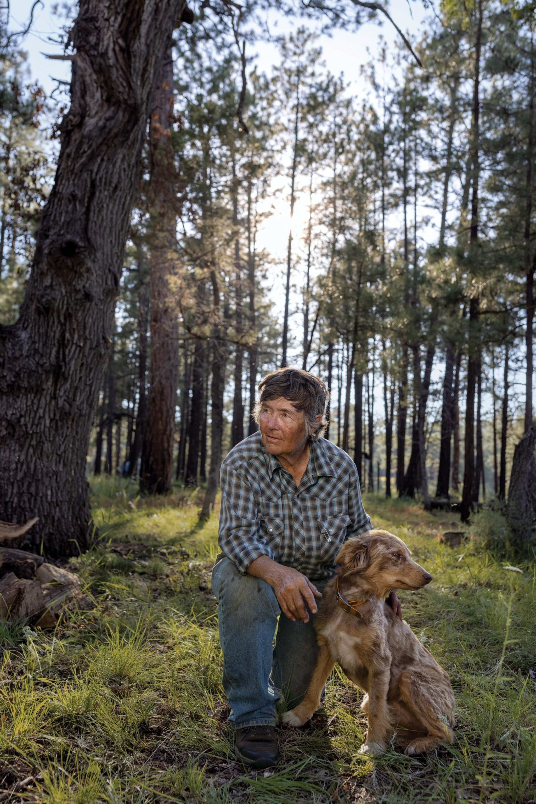 Woman on one knee holding dog.